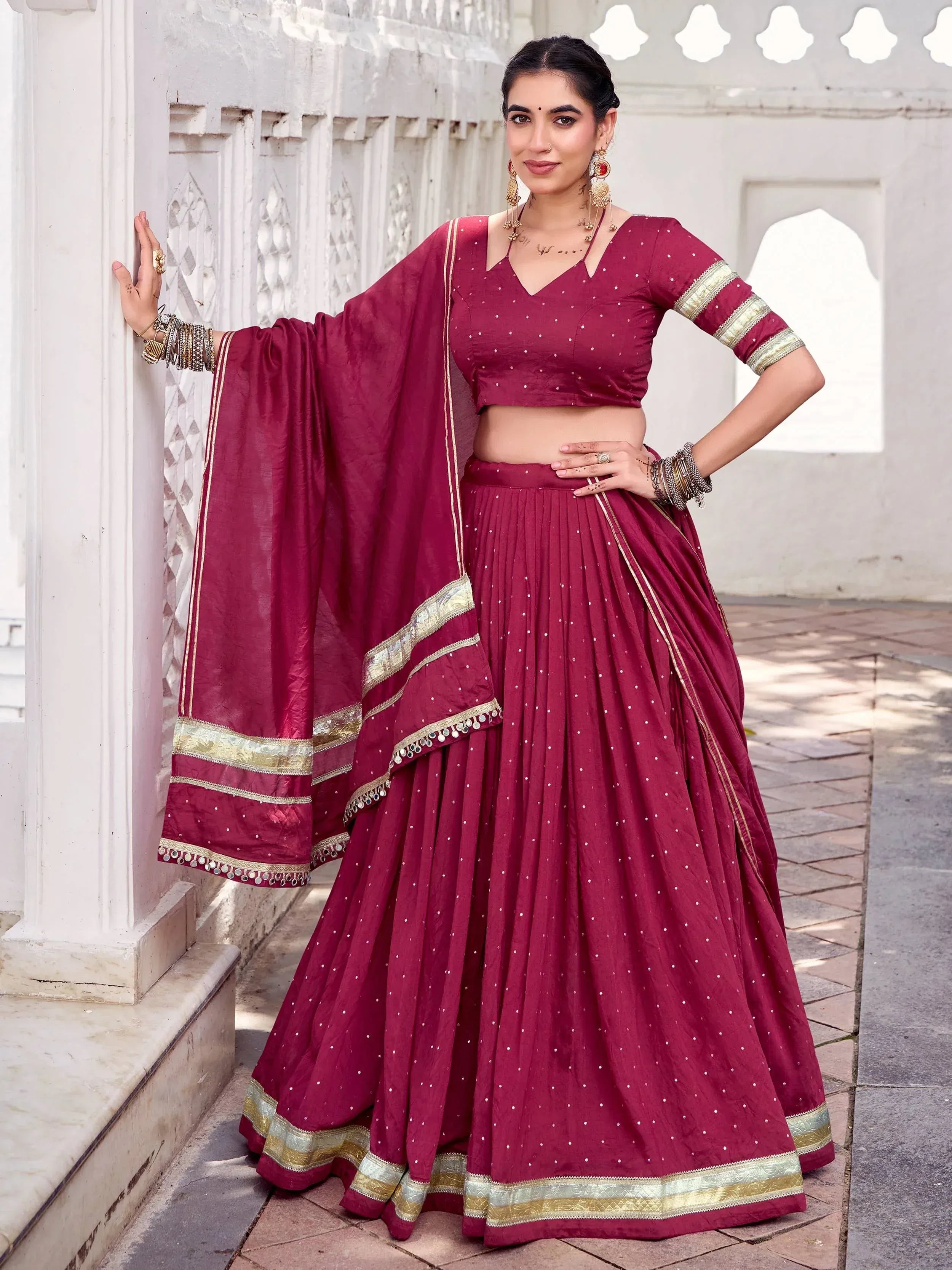 Maroon lehenga choli with gold trim and mirror work, perfect for Indian ethnic wear occasions