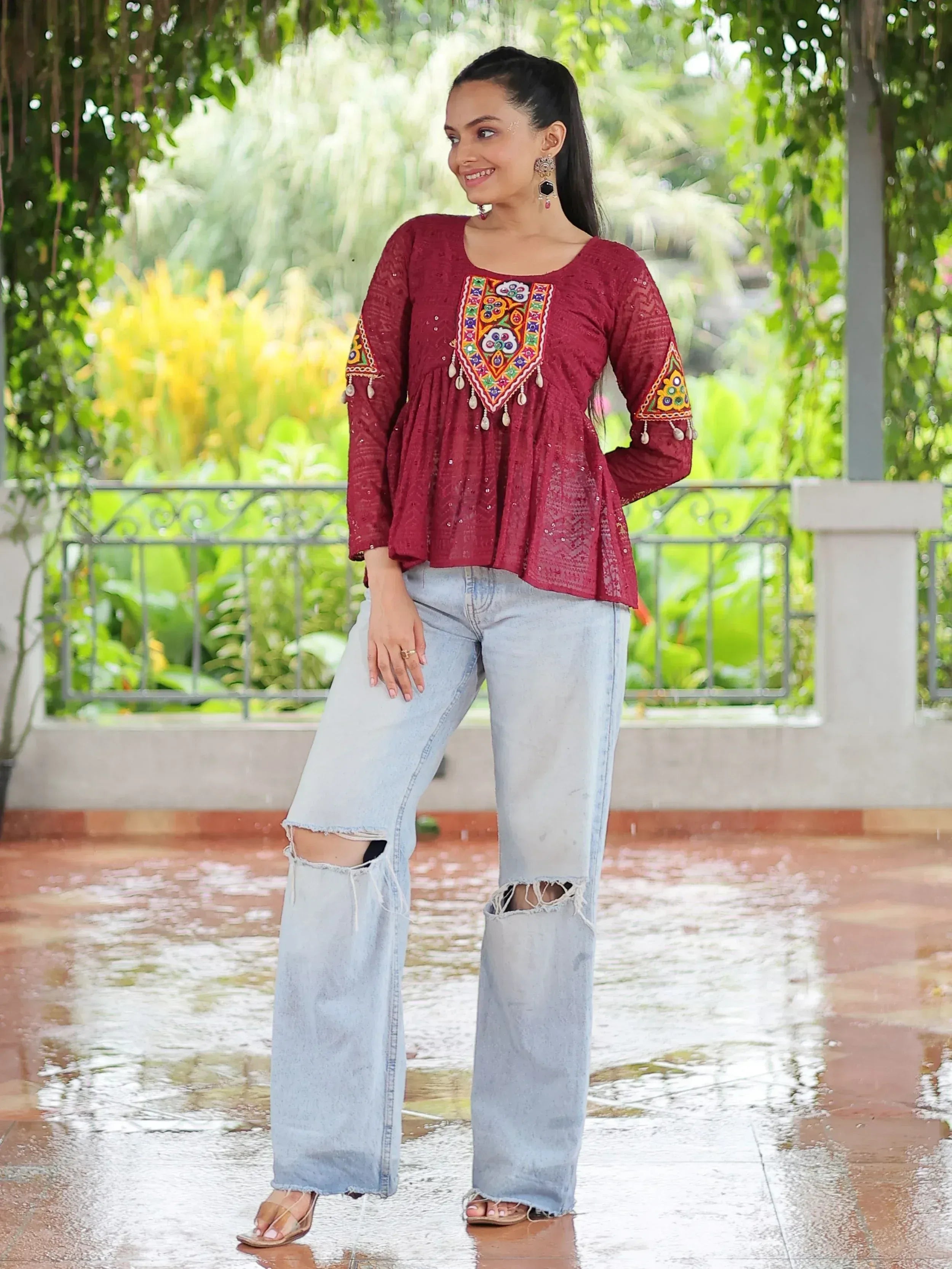 Maroon embroidered ethnic top with mirror work, paired with ripped wide-leg jeans, perfect for casual Indian wear.