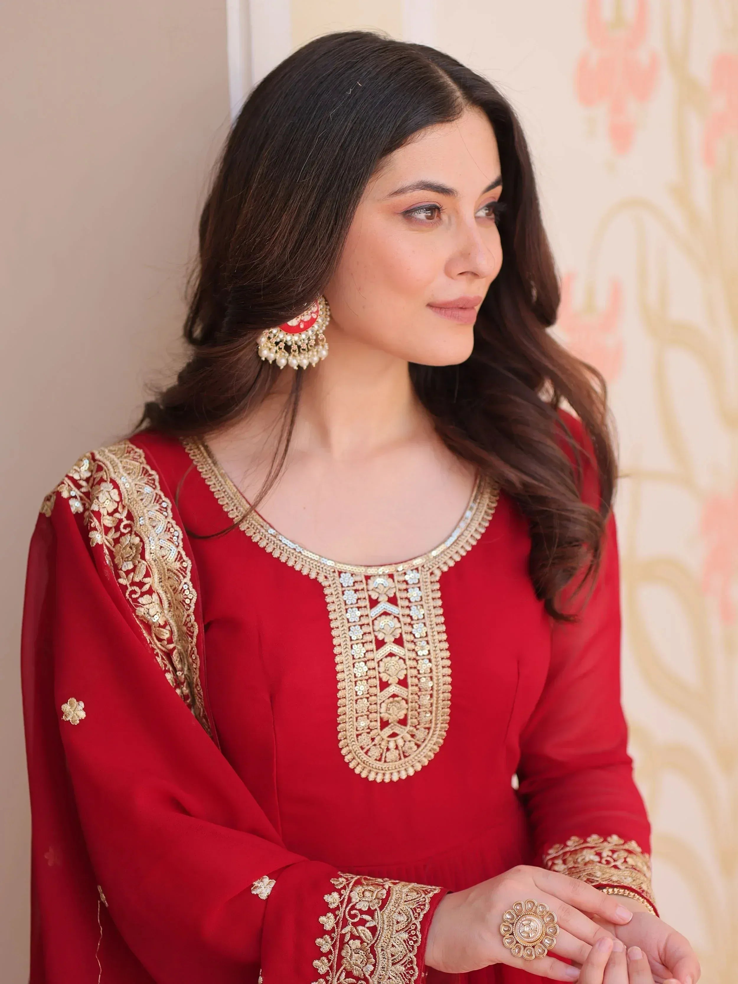 Red ethnic kurti with gold embroidery and mirror work, paired with statement earrings for festive occasions