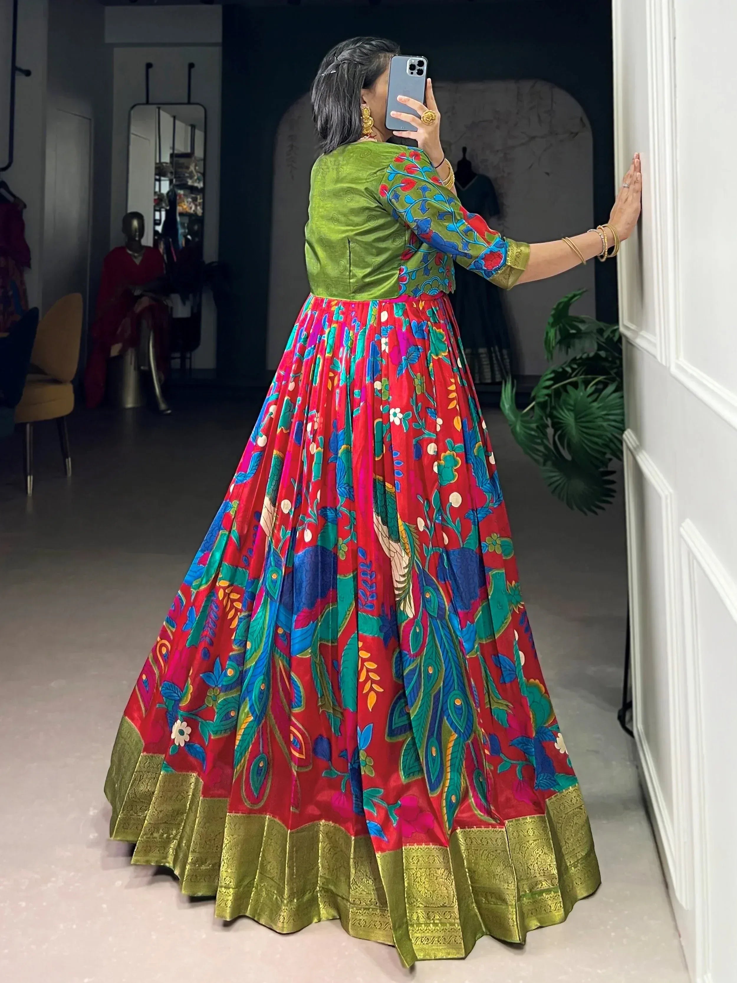 Vibrant red floral lehenga with peacock print, green blouse, and gold border, perfect for Indian ethnic wear.
