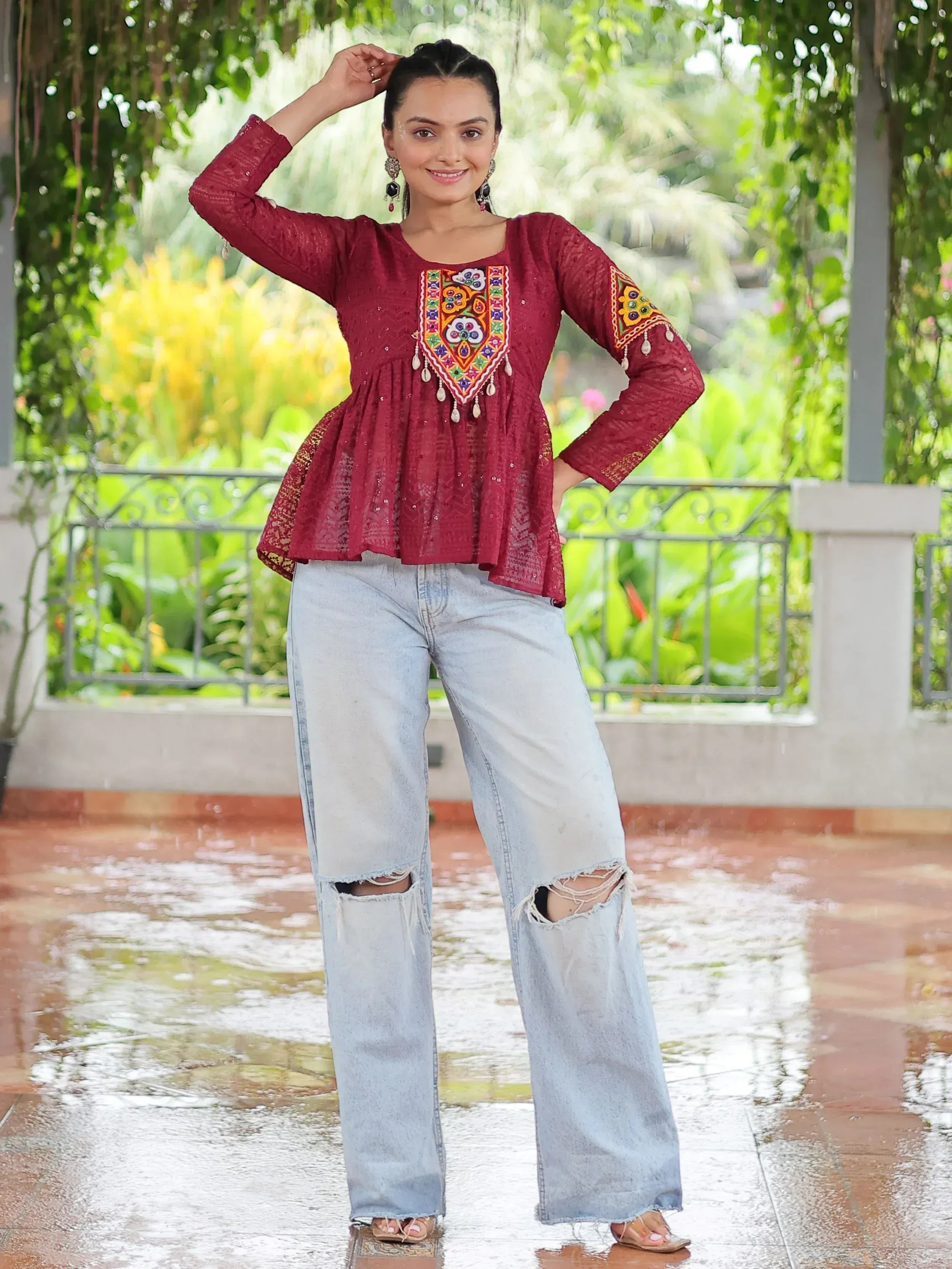 Maroon embroidered ethnic top with peplum hem paired with ripped wide-leg jeans, perfect for casual Indian wear.
