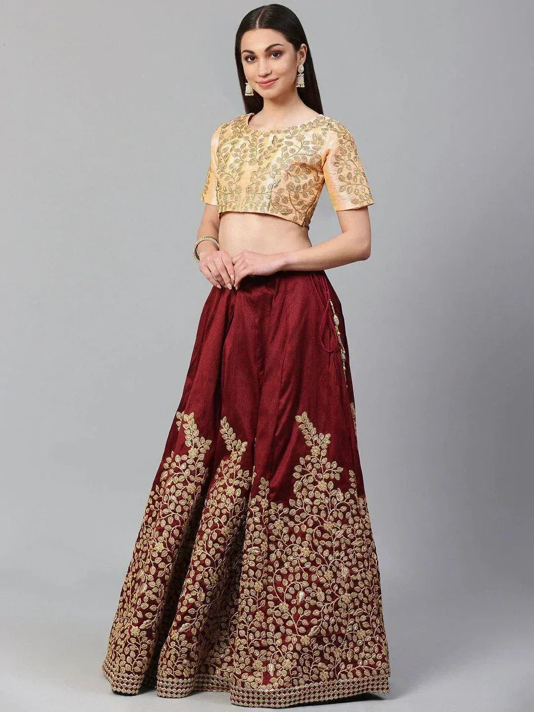 Maroon and gold embroidered lehenga choli with floral motifs, perfect for Indian ethnic wear occasions