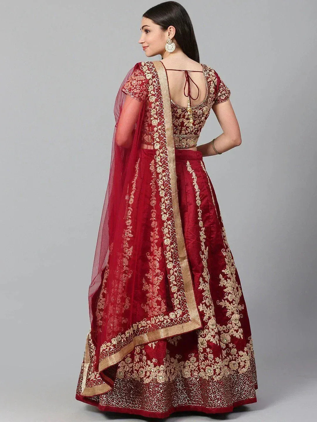 Maroon designer lehenga choli with gold embroidery and sheer dupatta, perfect for Indian weddings and festive occasions.