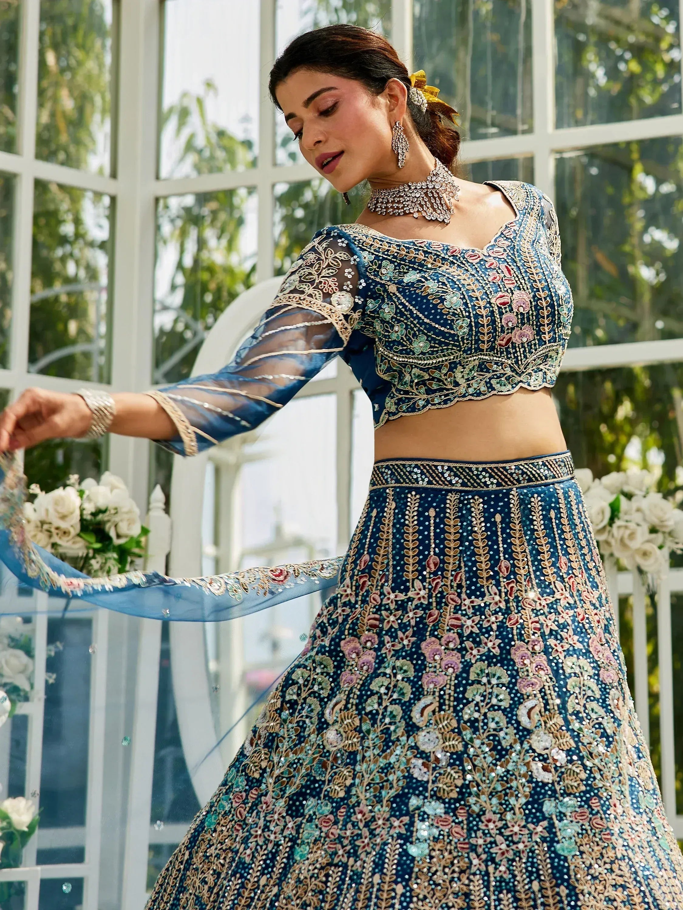 Blue embroidered lehenga choli with floral motifs, sheer sleeves, and matching dupatta for Indian ethnic wear