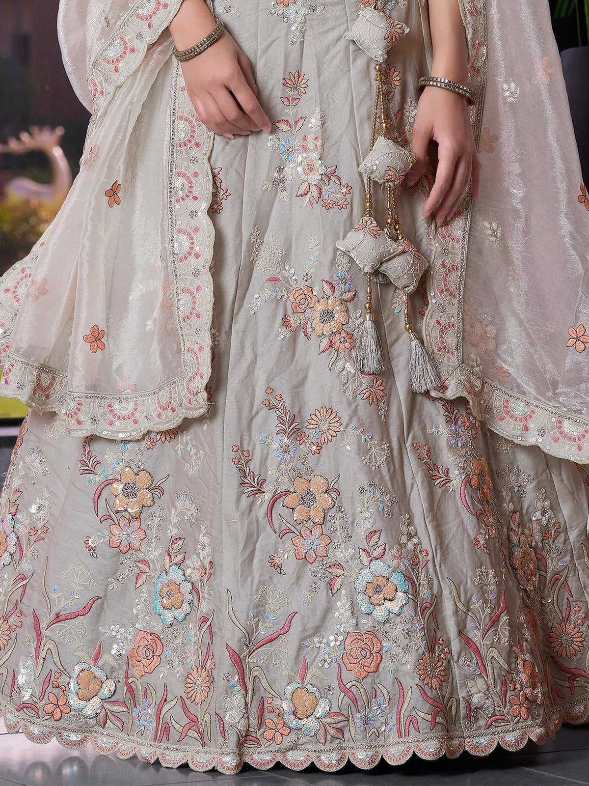 Elegant floral embroidered lehenga choli with pastel hues and tassel details, perfect for Indian ethnic occasions.