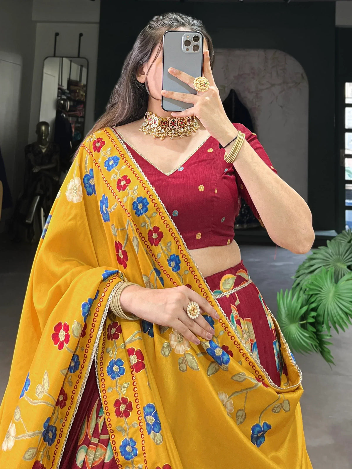 Woman in maroon lehenga choli with yellow floral dupatta, traditional Indian ethnic wear