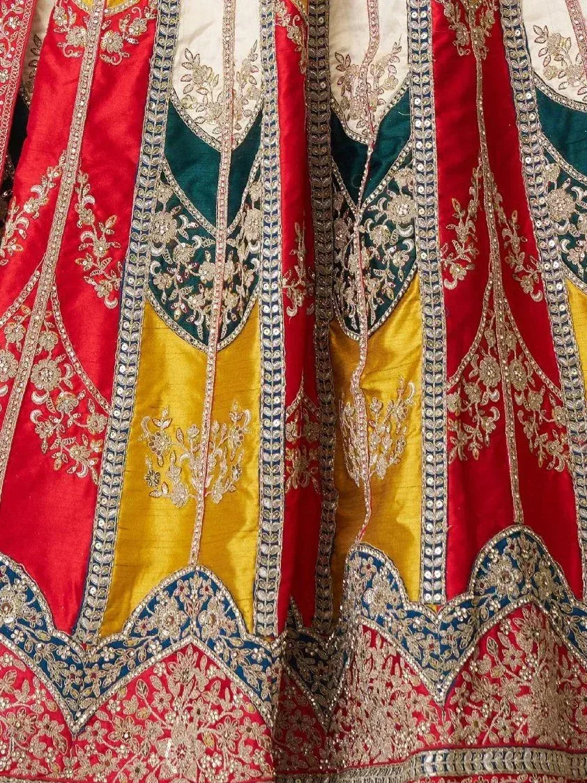 Red, green, and gold embroidered lehenga with intricate floral zari work and mirror detailing