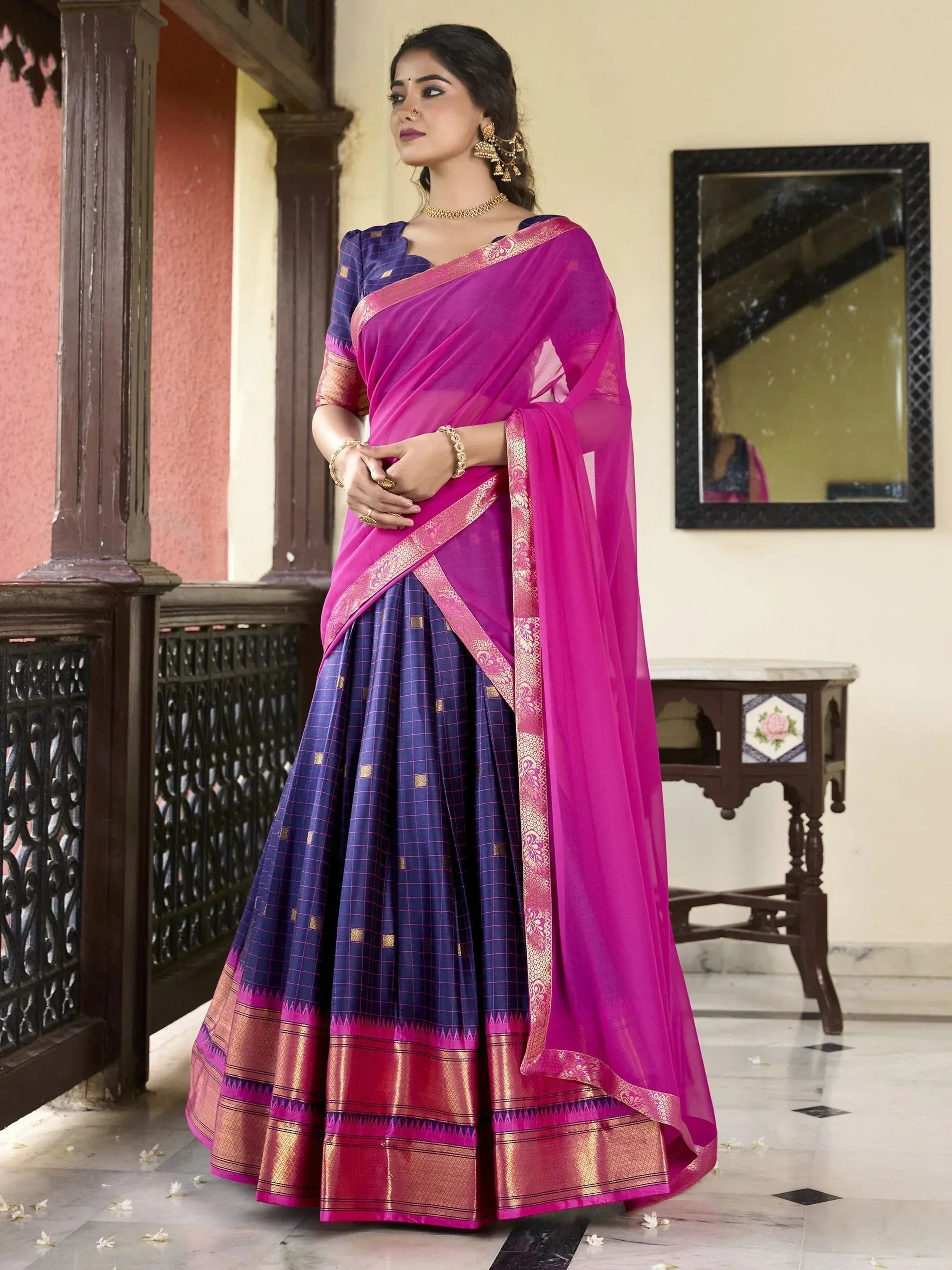 Woman in vibrant pink and navy blue designer saree with gold border, ethnic wear for festive occasions