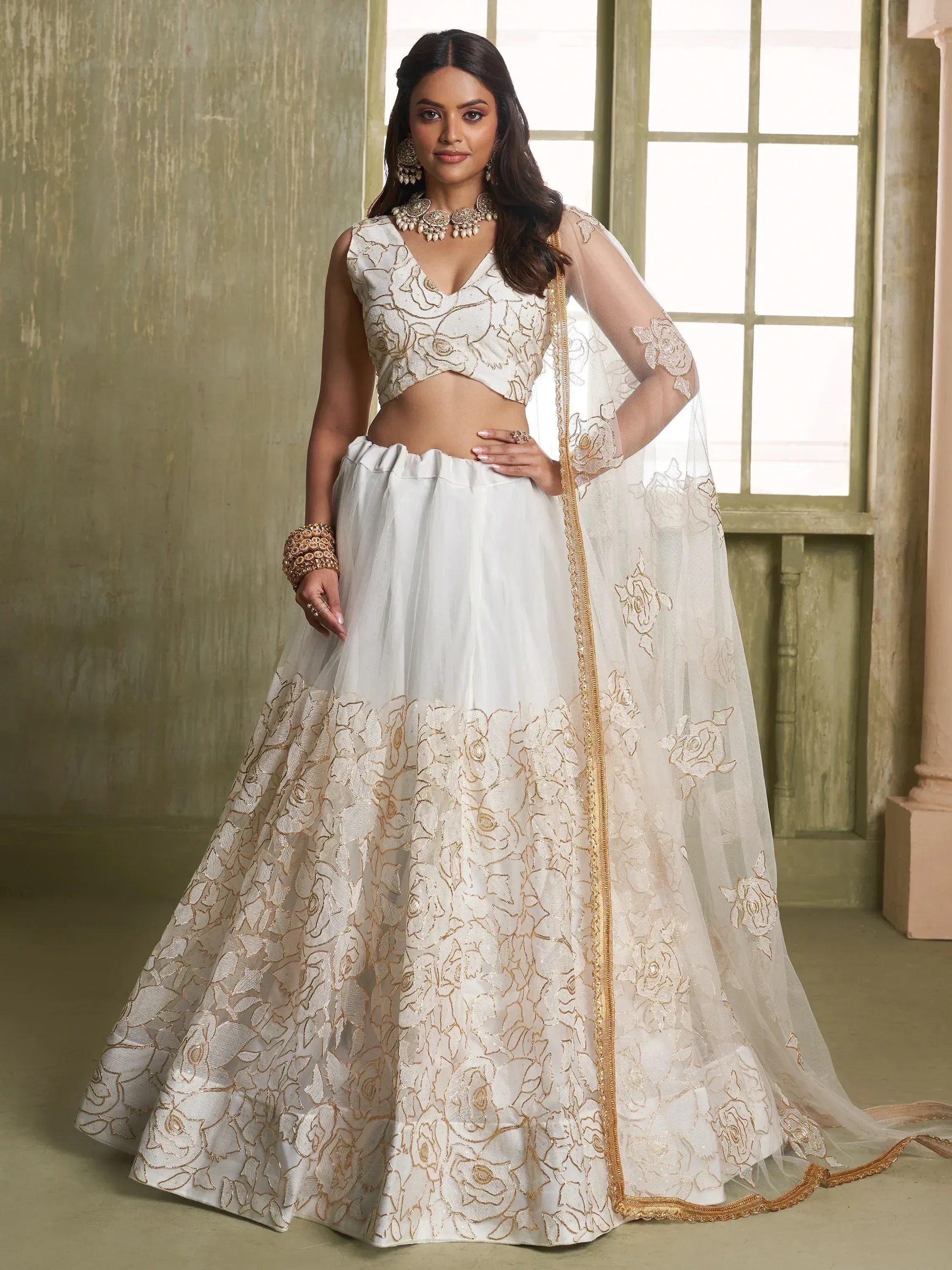 White and gold floral embroidered lehenga choli with sheer dupatta, perfect for Indian weddings and festive occasions.