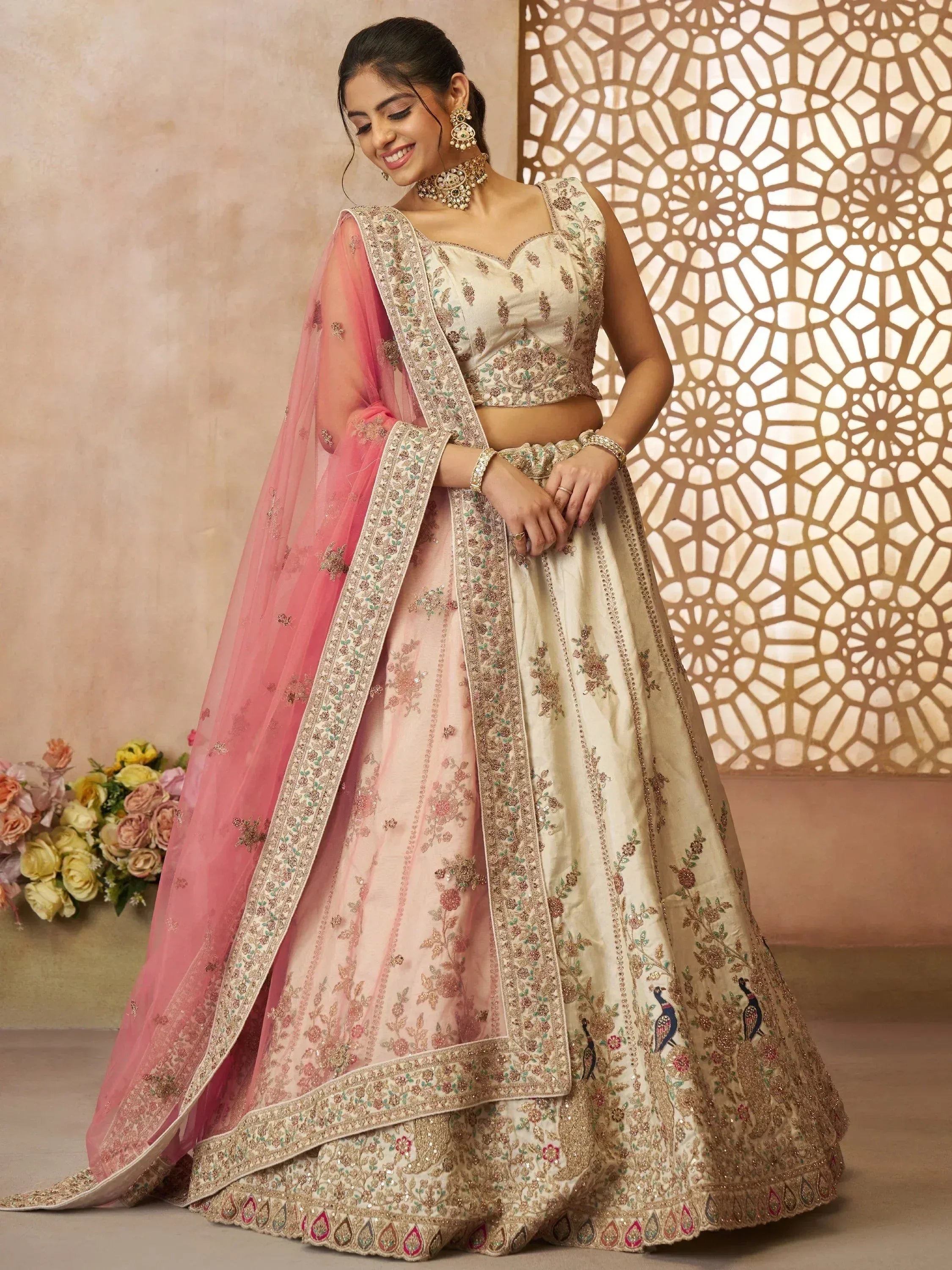 Elegant ivory and pink embroidered lehenga choli with peacock motifs, perfect for Indian weddings and festive occasions.