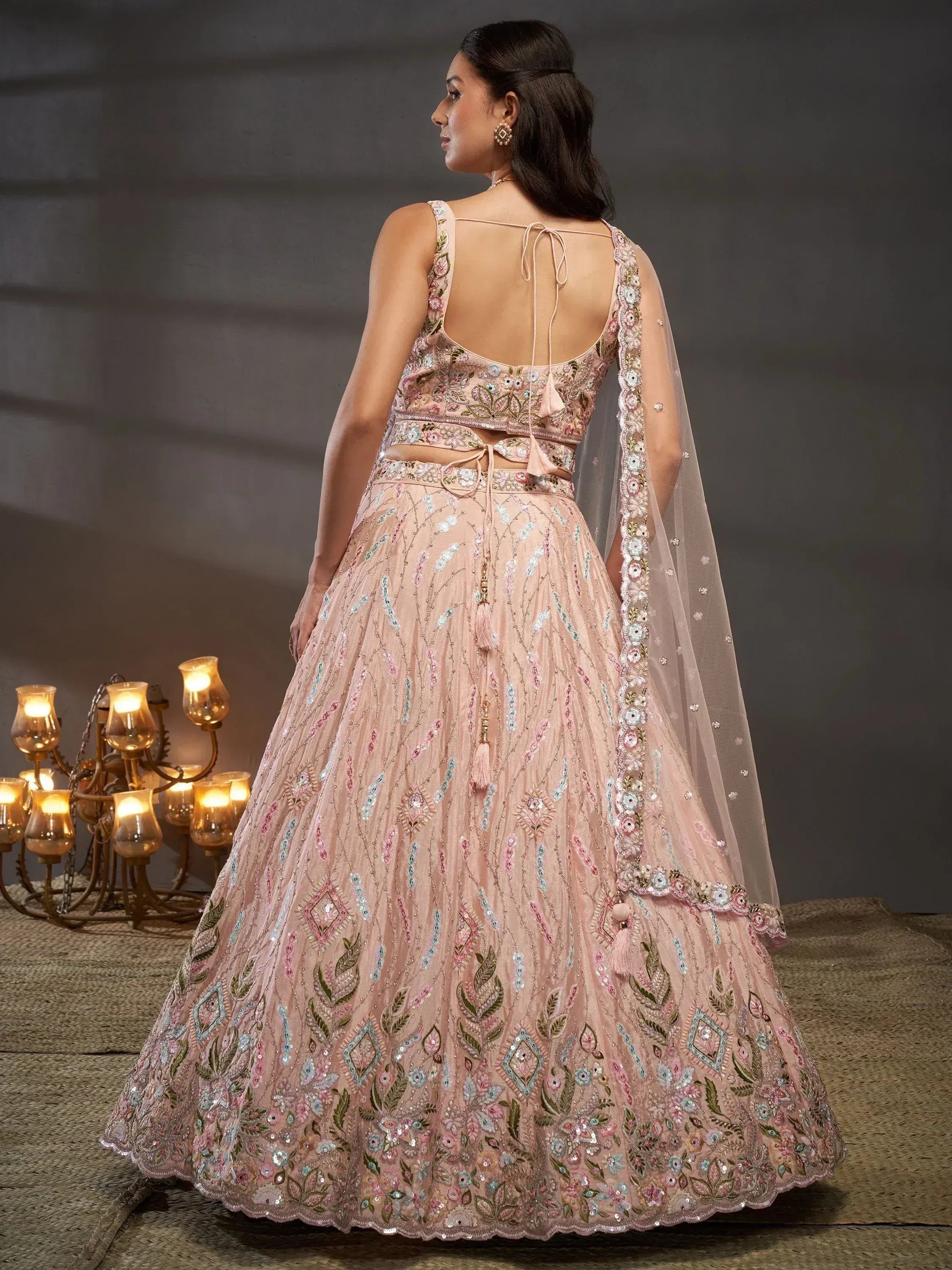 Elegant pink embroidered lehenga choli with floral motifs and sheer dupatta, perfect for Indian weddings and festive occasions.