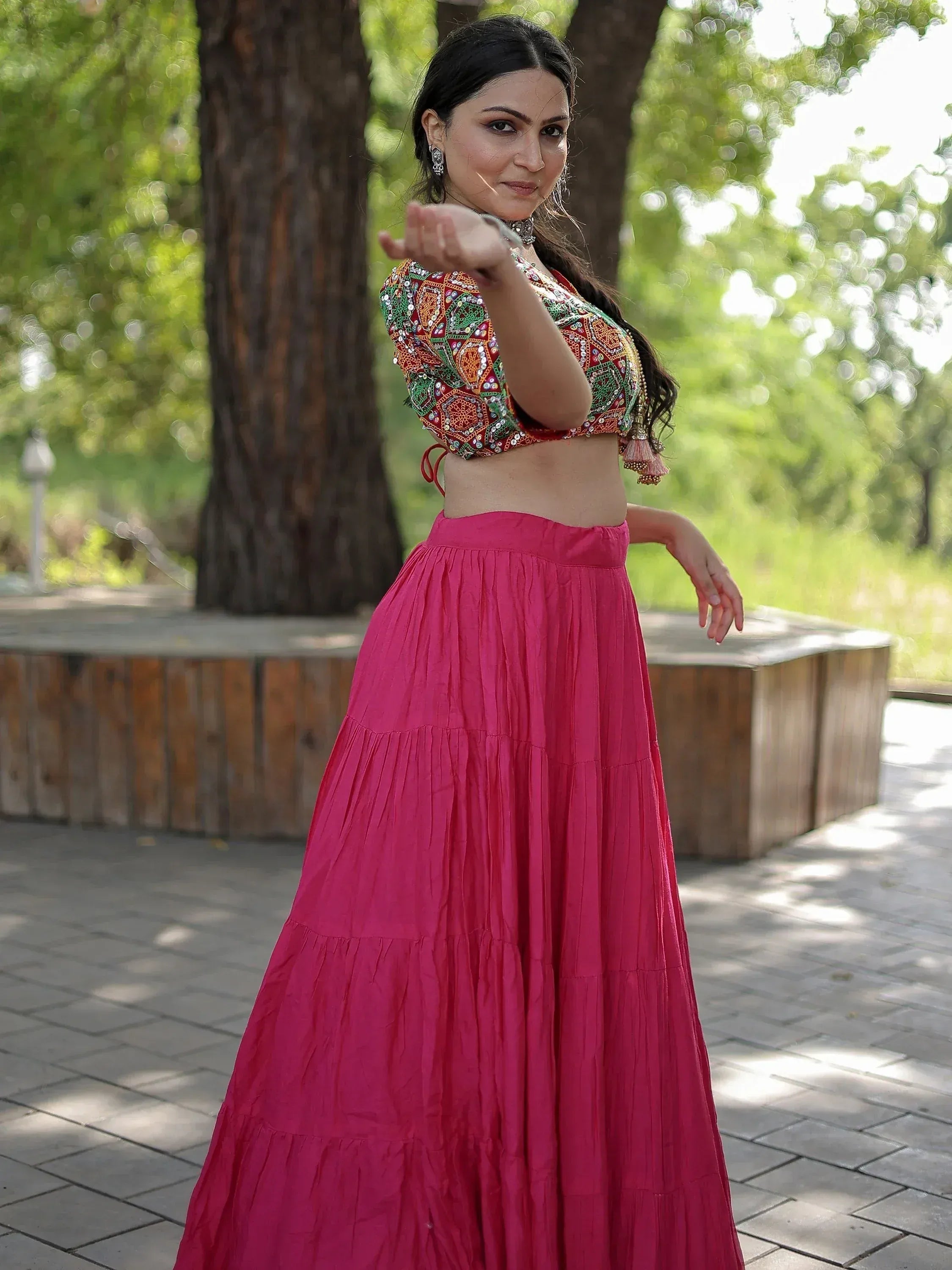 Woman in vibrant pink ethnic skirt and embroidered crop top, perfect for Indian festive wear