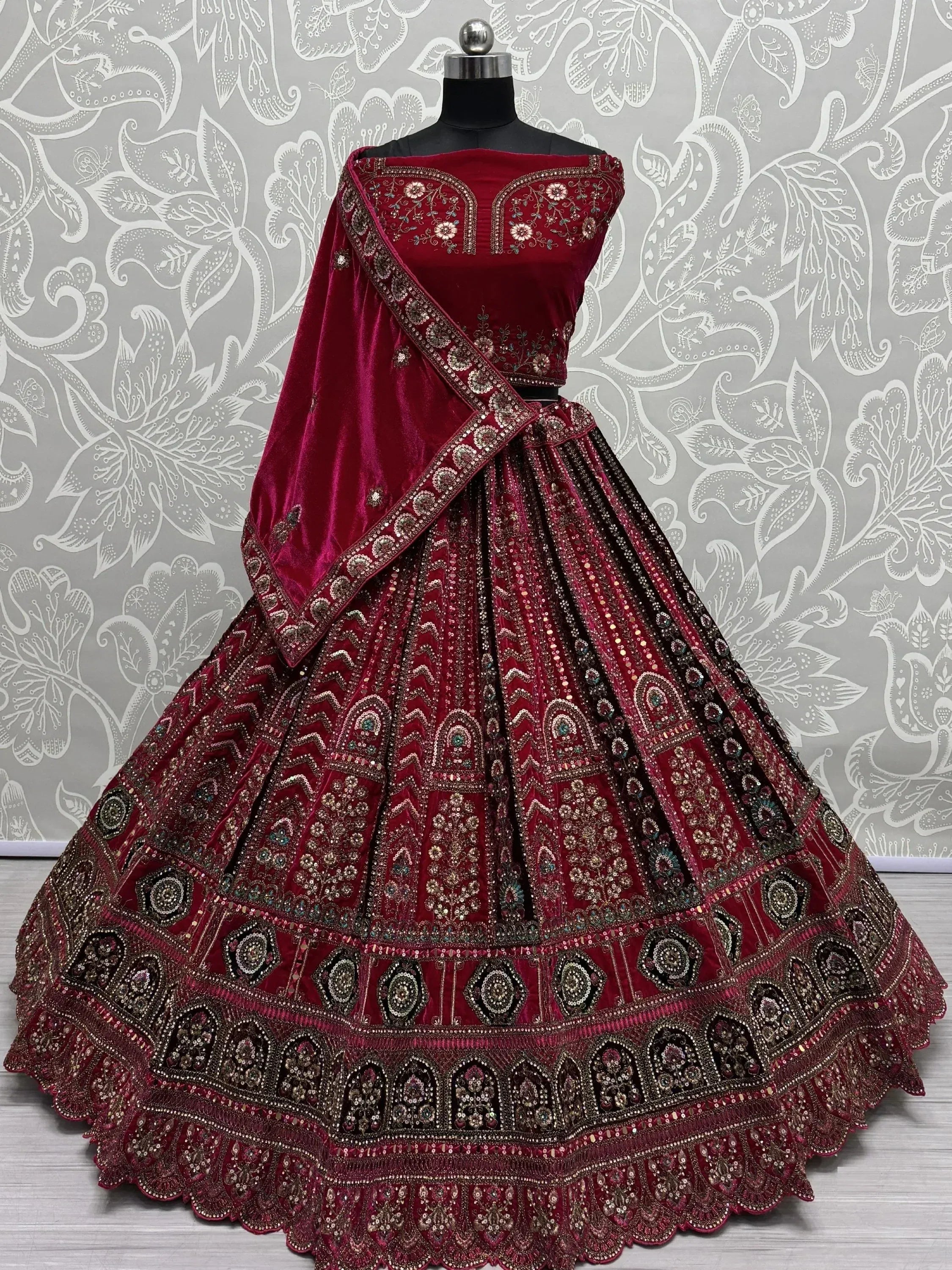 Maroon velvet lehenga choli with heavy embroidery and sequins, perfect for Indian weddings and festive occasions.