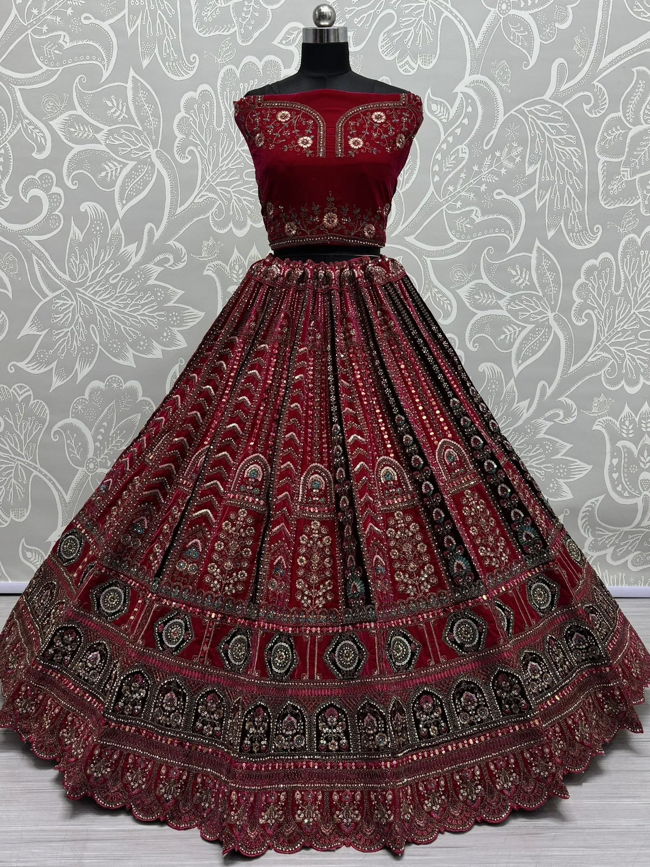 Maroon velvet designer lehenga choli with heavy embroidery and sequins, perfect for Indian weddings and festive occasions.