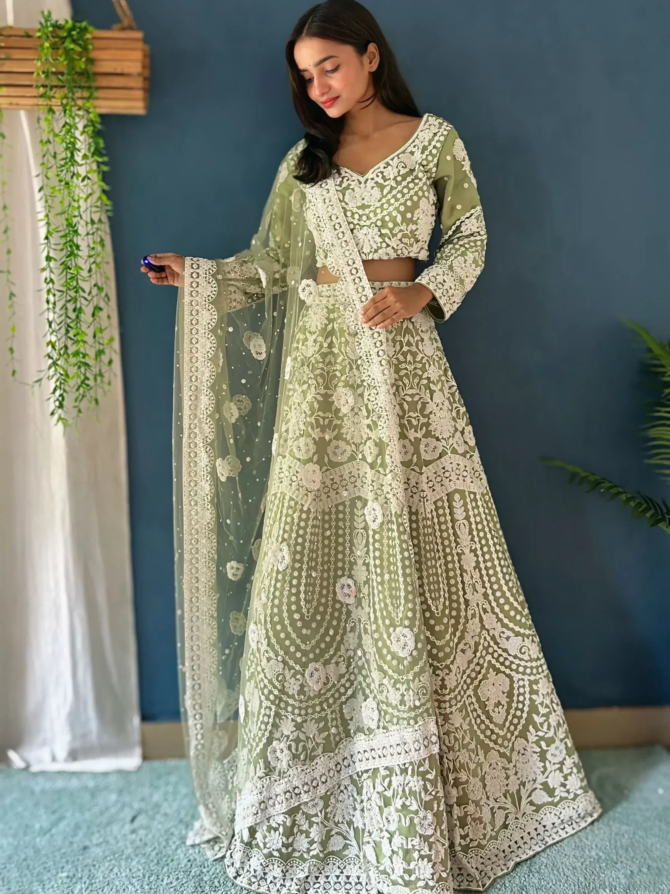 Olive green designer lehenga choli with white floral embroidery and sheer dupatta, perfect for Indian ethnic wear.