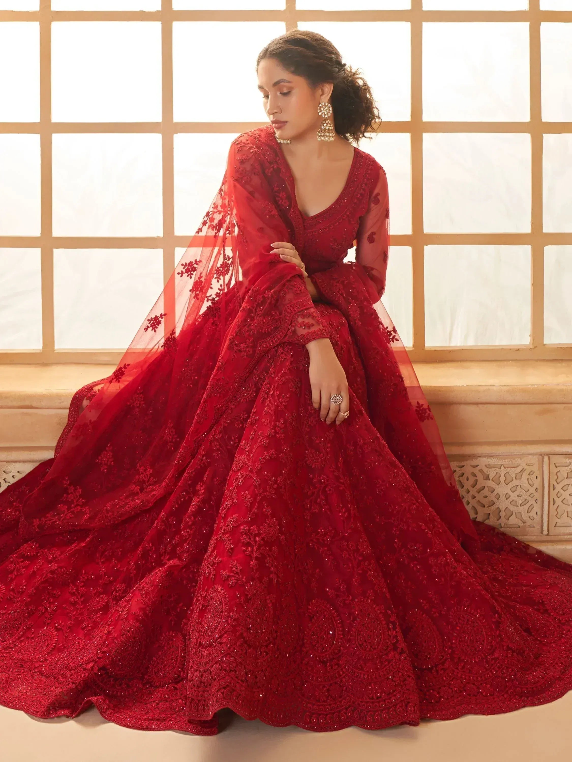 Red embroidered designer lehenga choli with sheer dupatta, perfect for Indian weddings and festive occasions