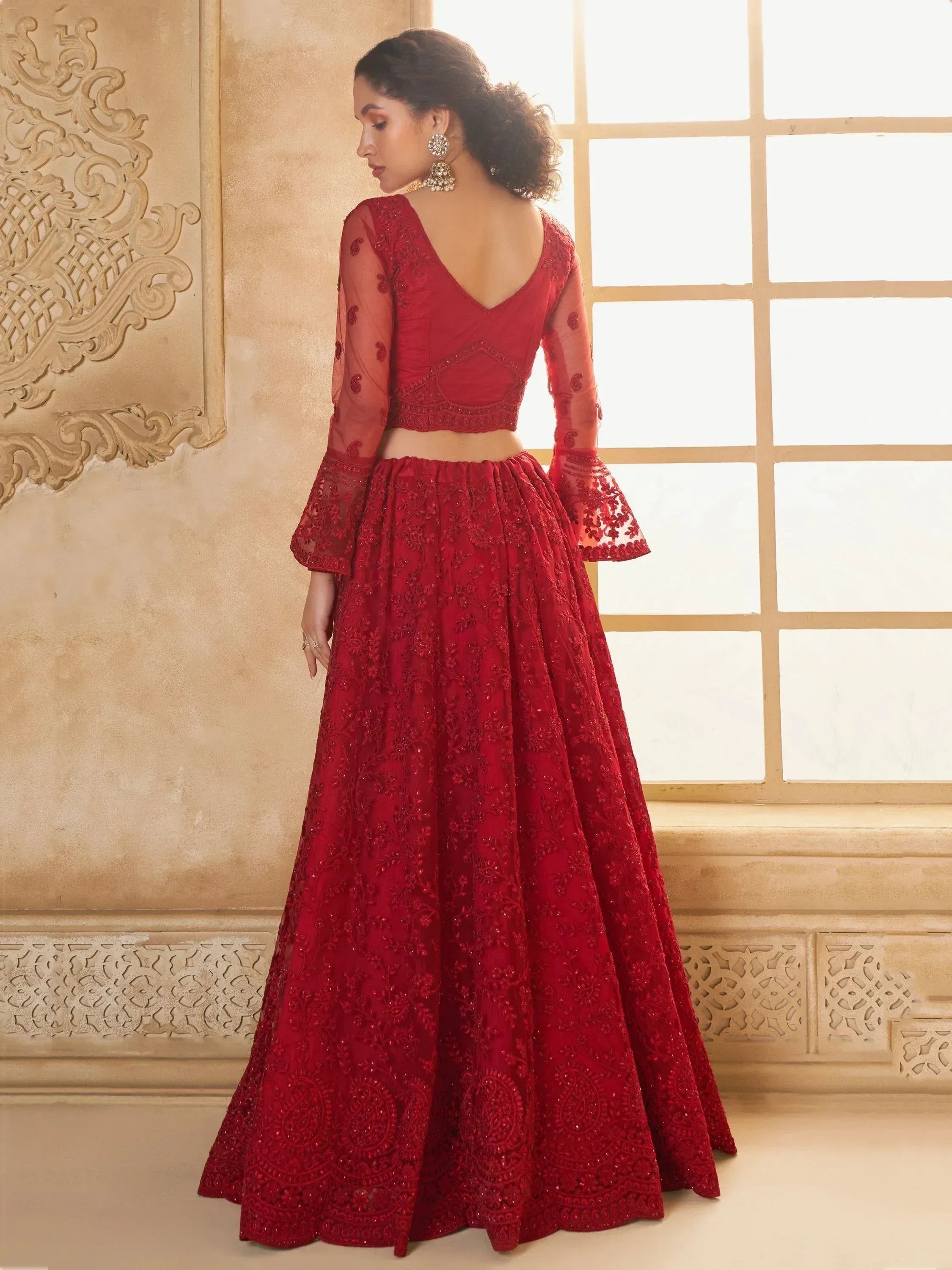 Red embroidered lehenga choli with sheer sleeves, perfect for weddings and festive occasions