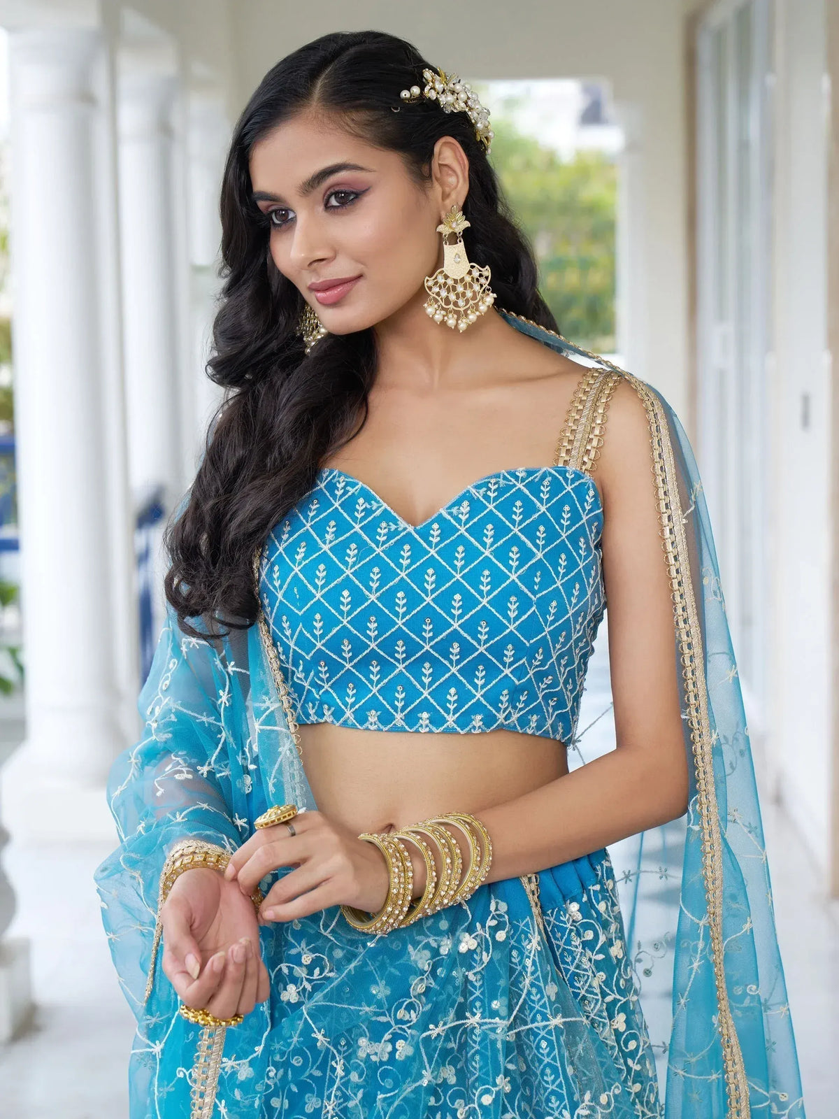 Blue embroidered lehenga choli with gold jewelry, perfect for Indian ethnic wear and festive occasions.