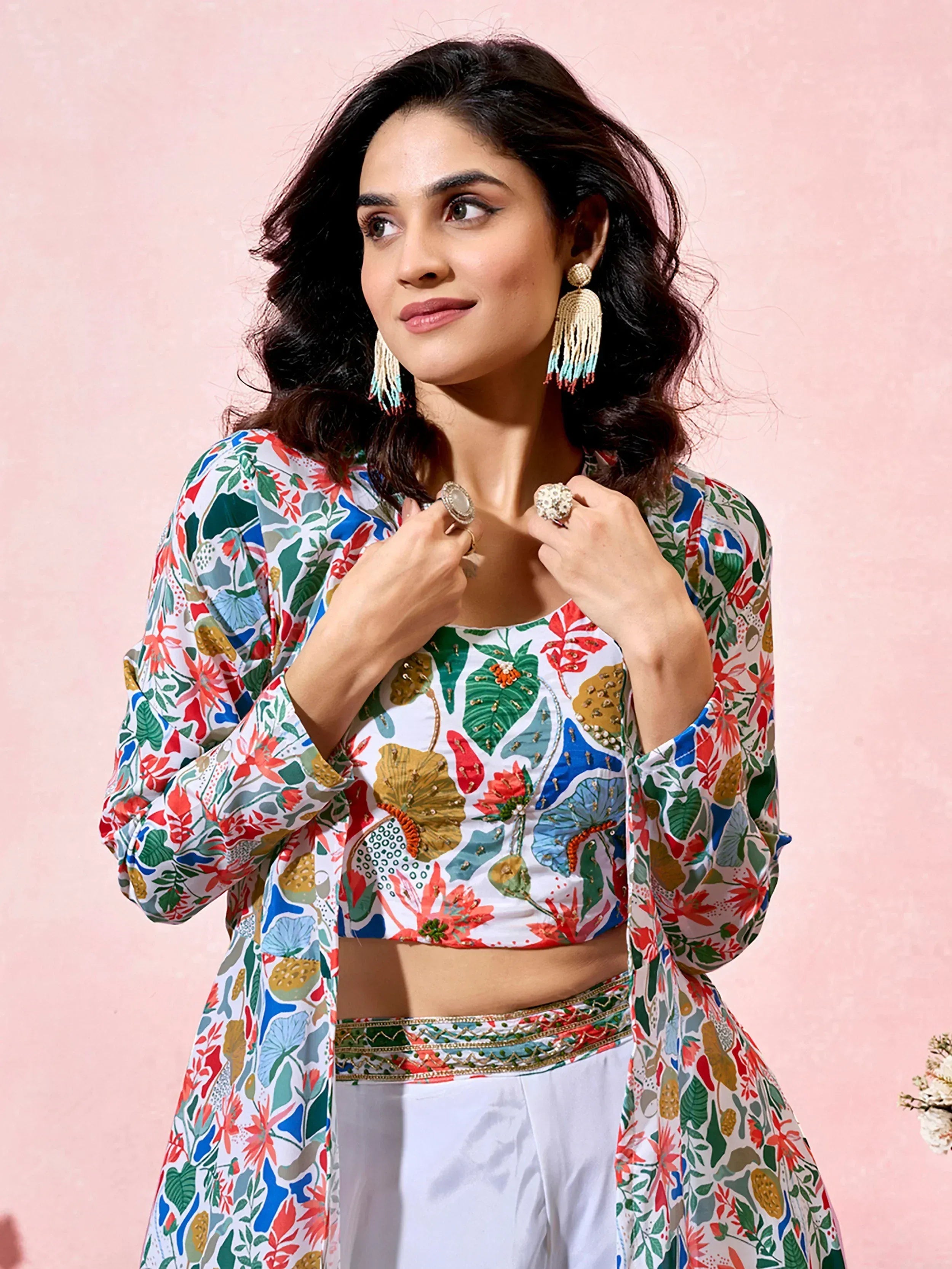 Floral printed Indian ethnic crop top with matching jacket and white palazzo pants, styled with tassel earrings.
