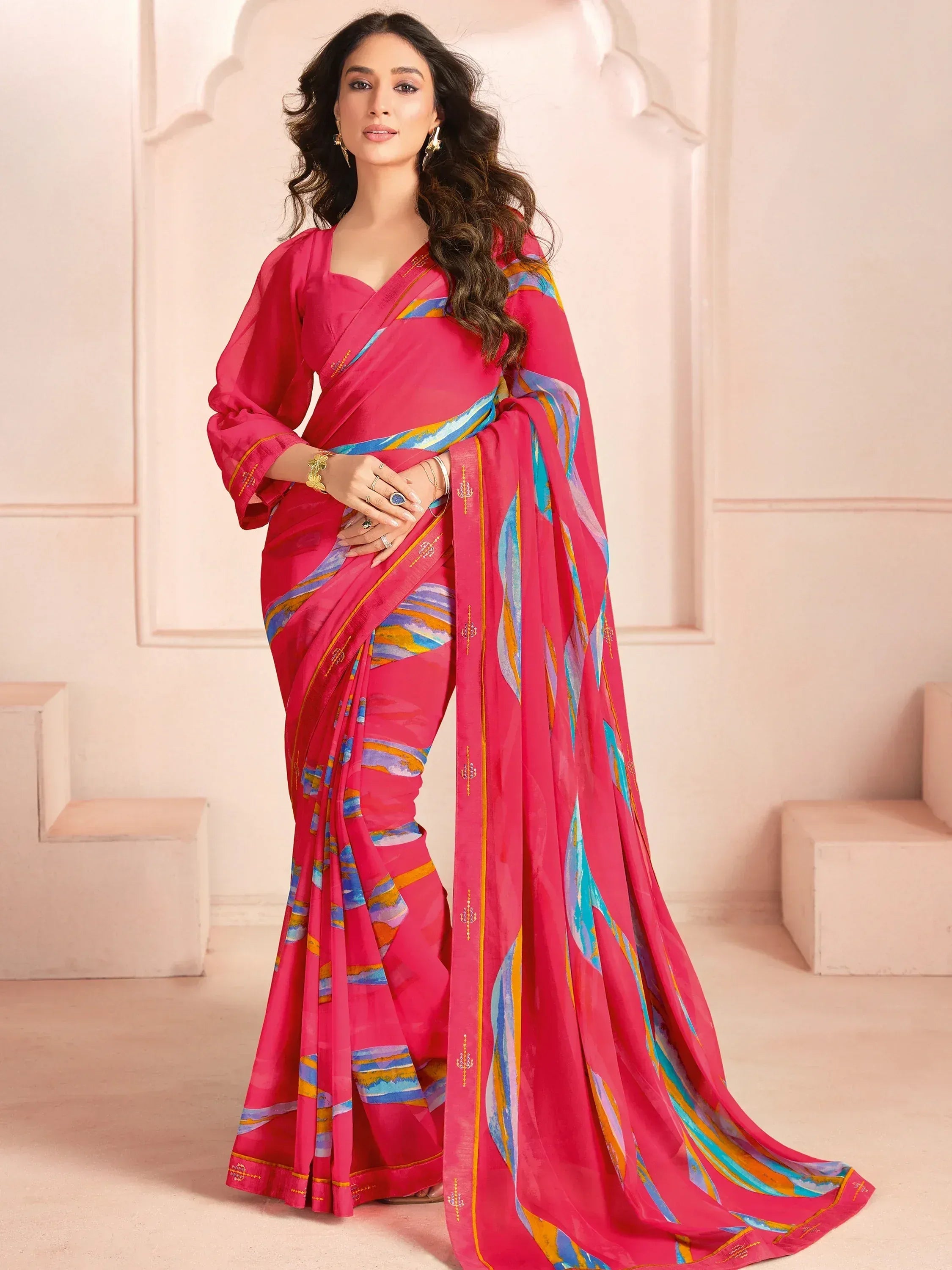 Vibrant pink saree with blue and gold abstract print, perfect for Indian ethnic wear occasions