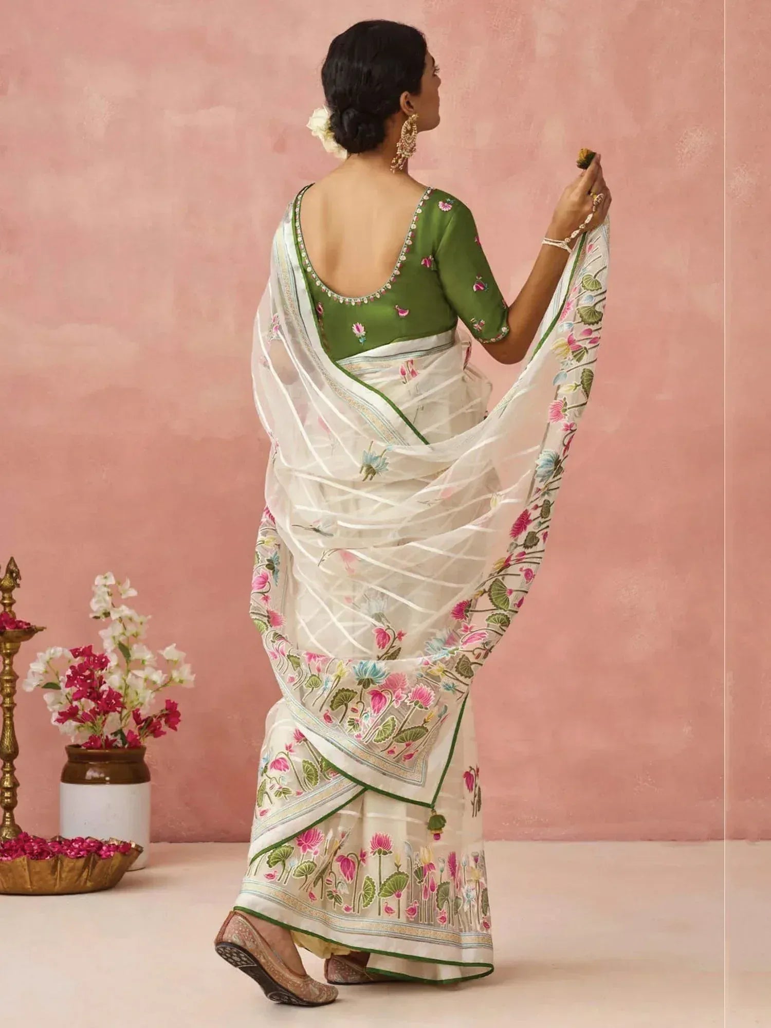 Woman in white floral saree with green blouse, ethnic Indian wear, back view