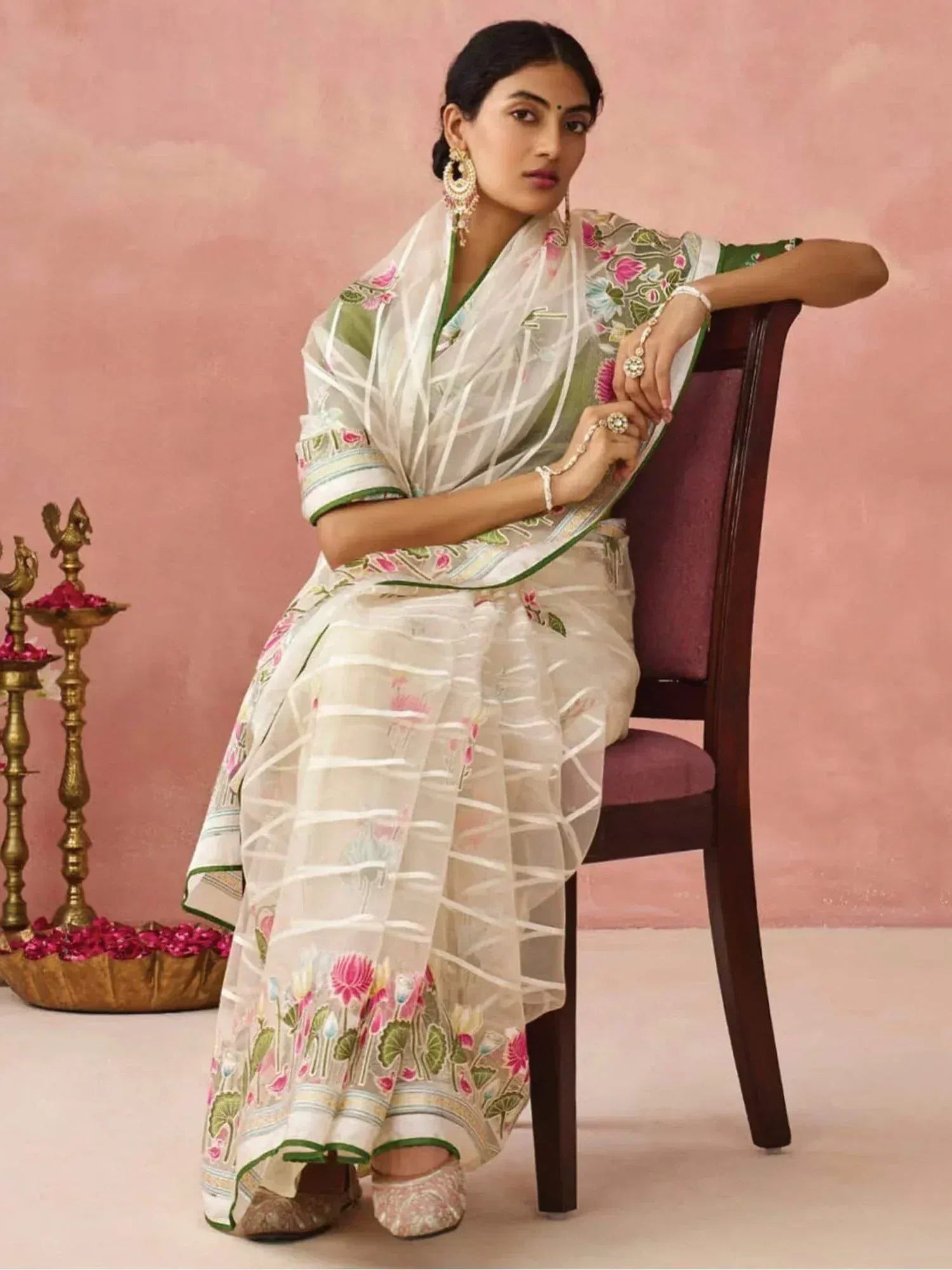 Woman in elegant floral embroidered saree with green border, traditional Indian ethnic wear