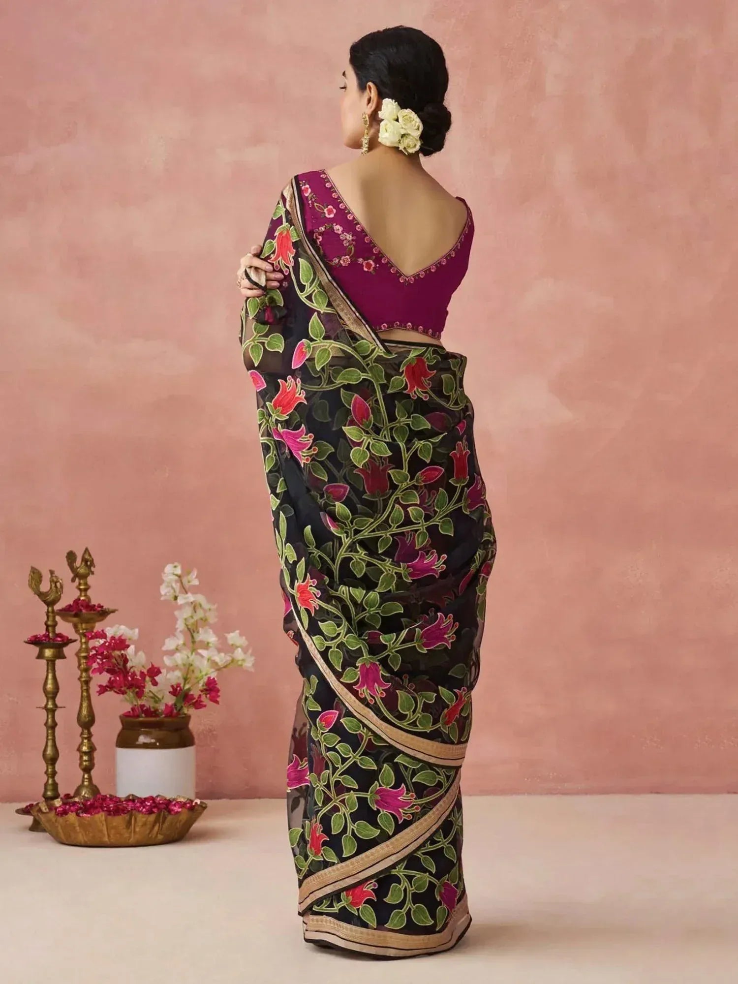 Black floral saree with pink and green print, paired with a maroon blouse, styled for Indian ethnic wear.