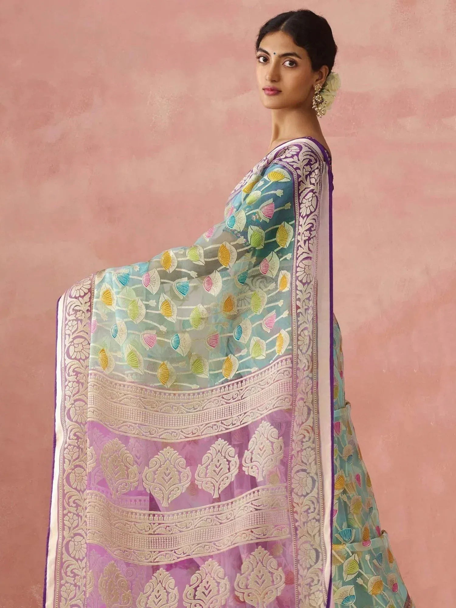 Woman in colorful embroidered saree with floral and paisley designs, perfect for Indian ethnic wear occasions