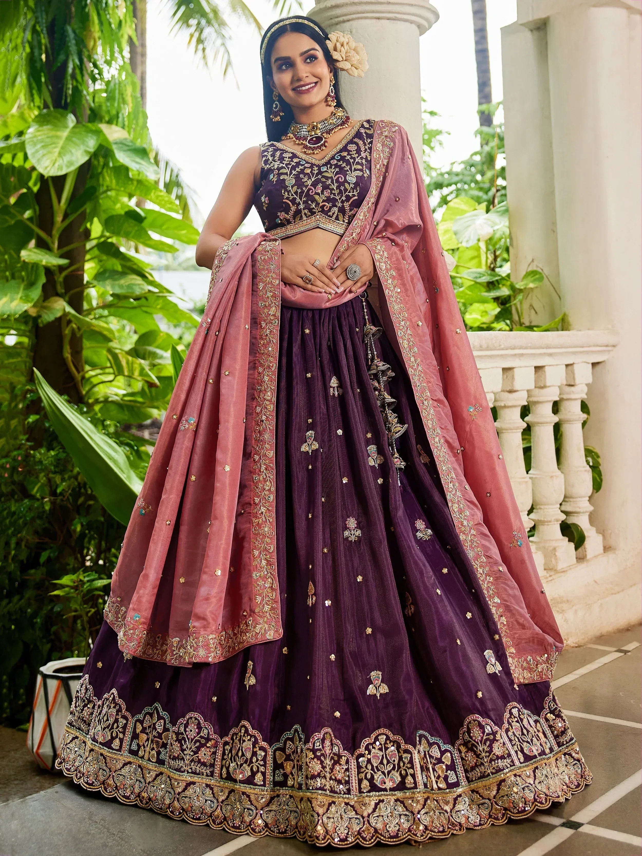 Elegant purple lehenga choli with gold embroidery and pink dupatta, perfect for Indian weddings and festive occasions.