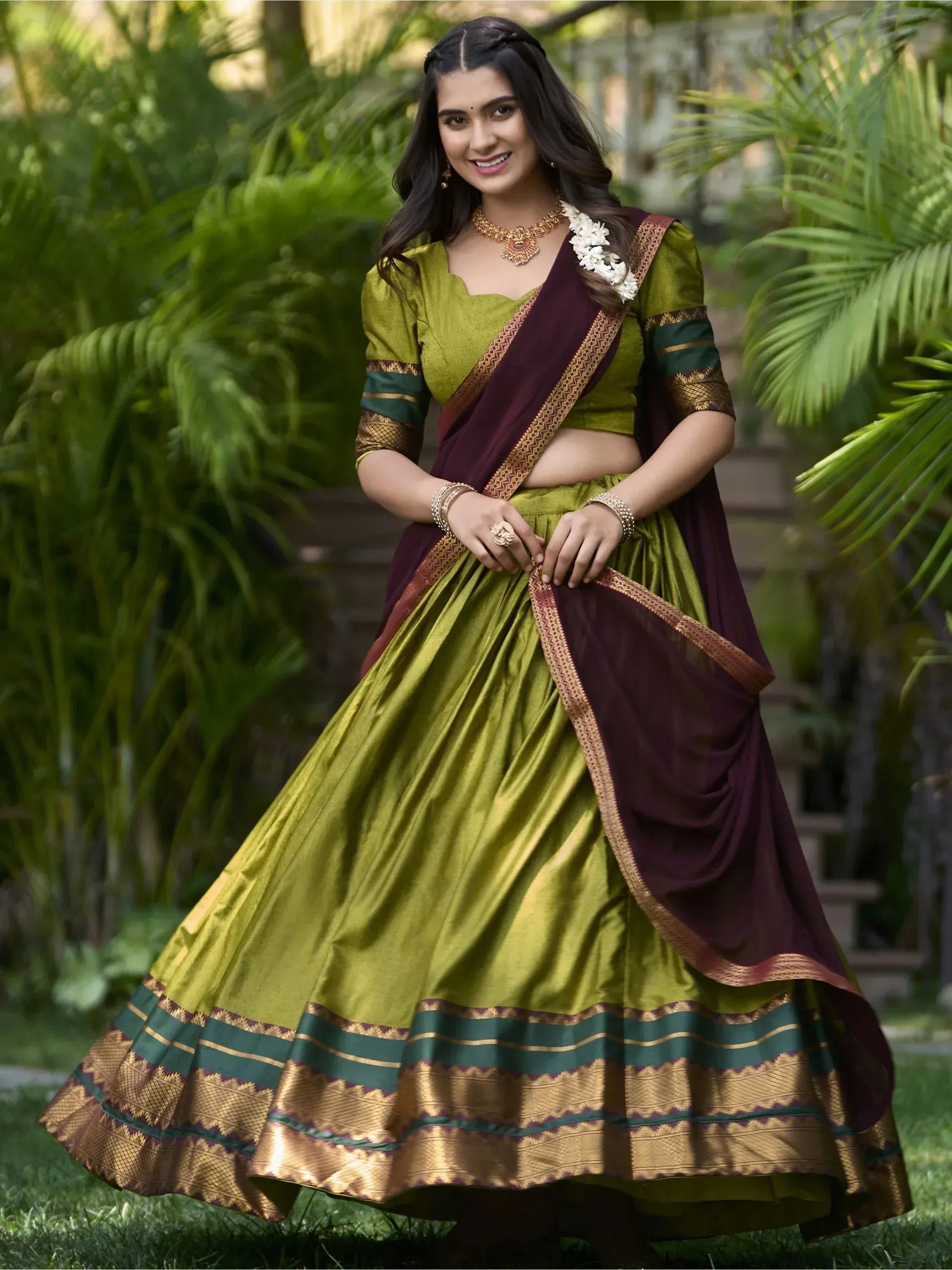 Woman in olive green and maroon lehenga choli with gold border, traditional Indian ethnic wear