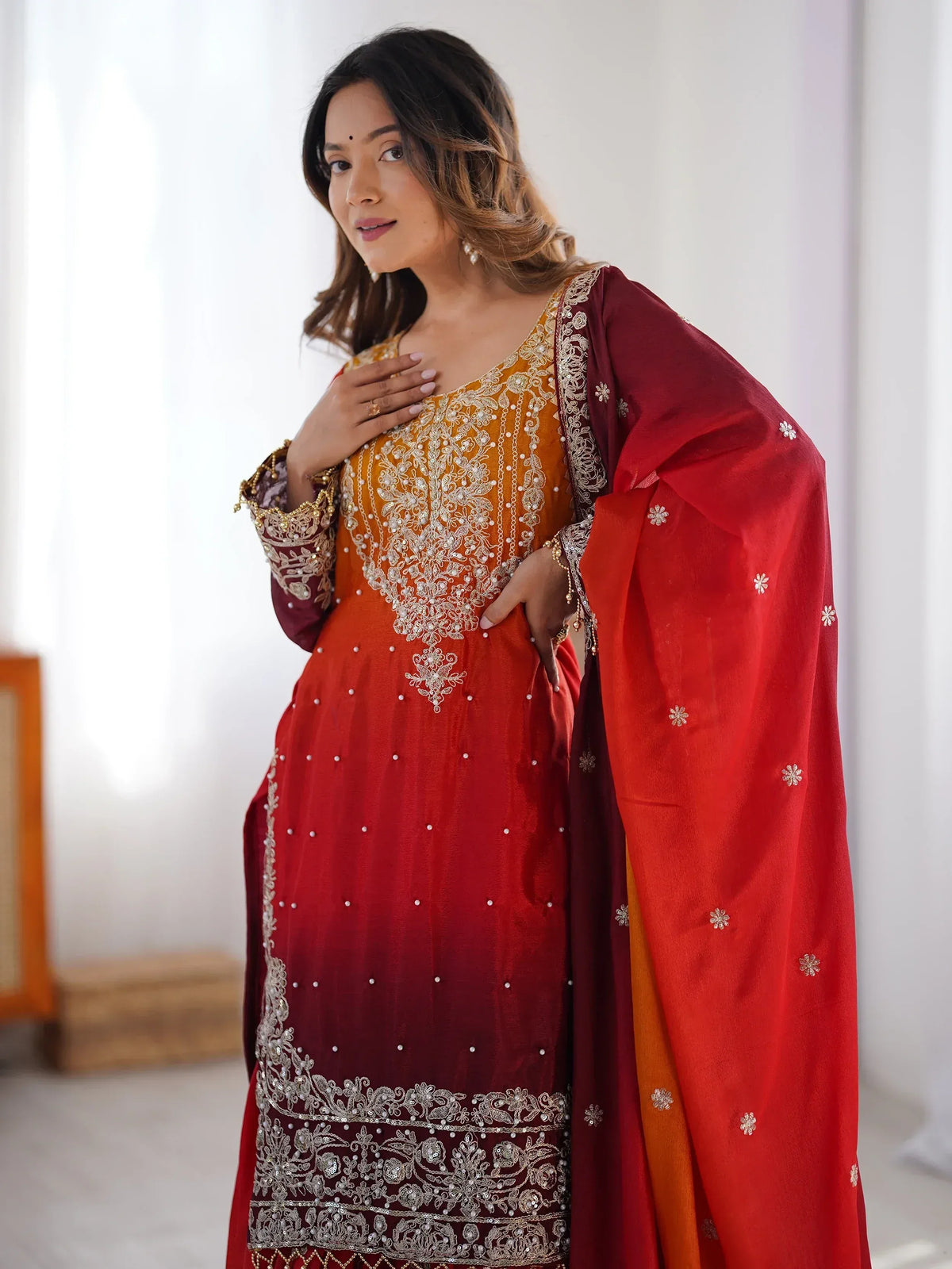 Red and gold embroidered Indian ethnic gown with matching dupatta, perfect for weddings and festive occasions.