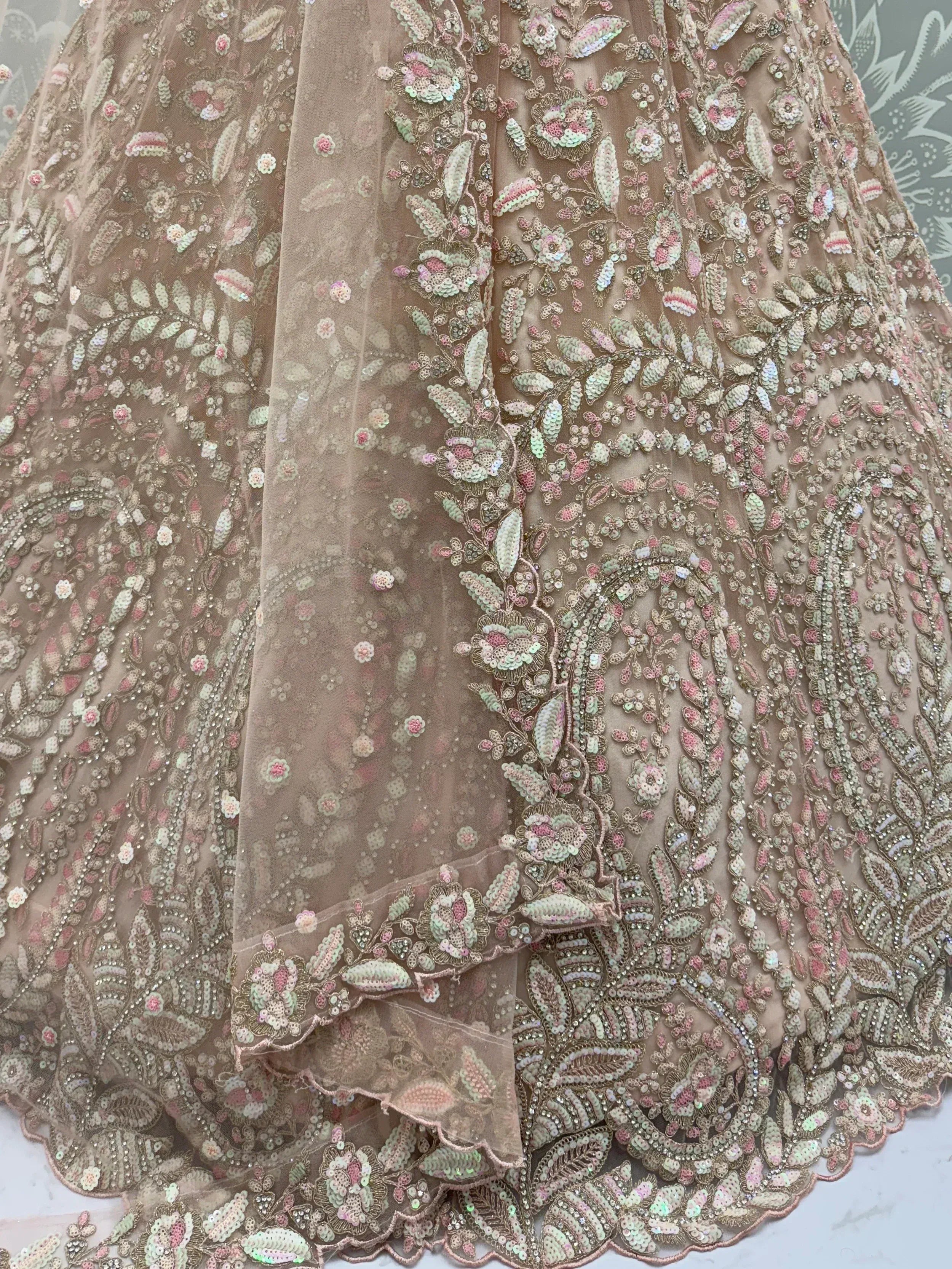 Elegant beige lehenga with intricate floral sequin embroidery and sheer overlay, perfect for Indian ethnic wear.