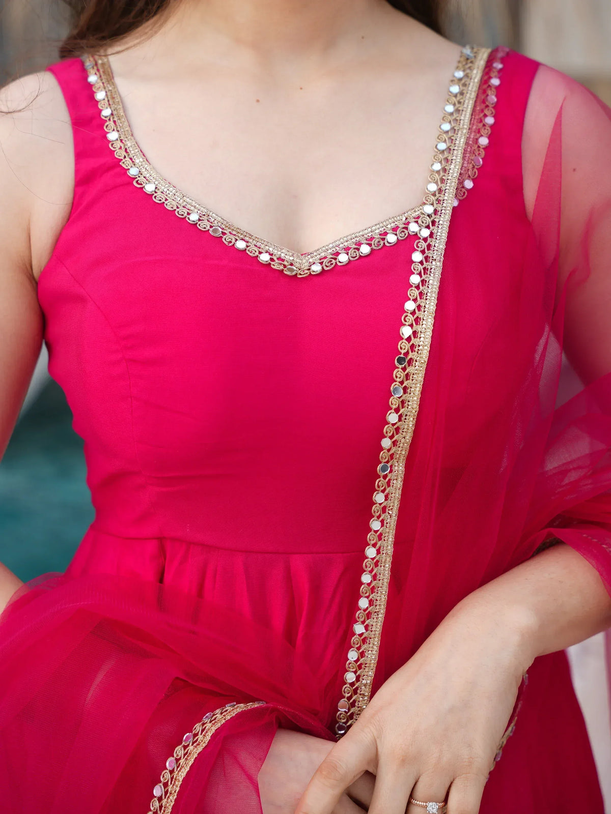 Pink ethnic gown with gold mirror work and sheer sleeves, perfect for Indian festive occasions.