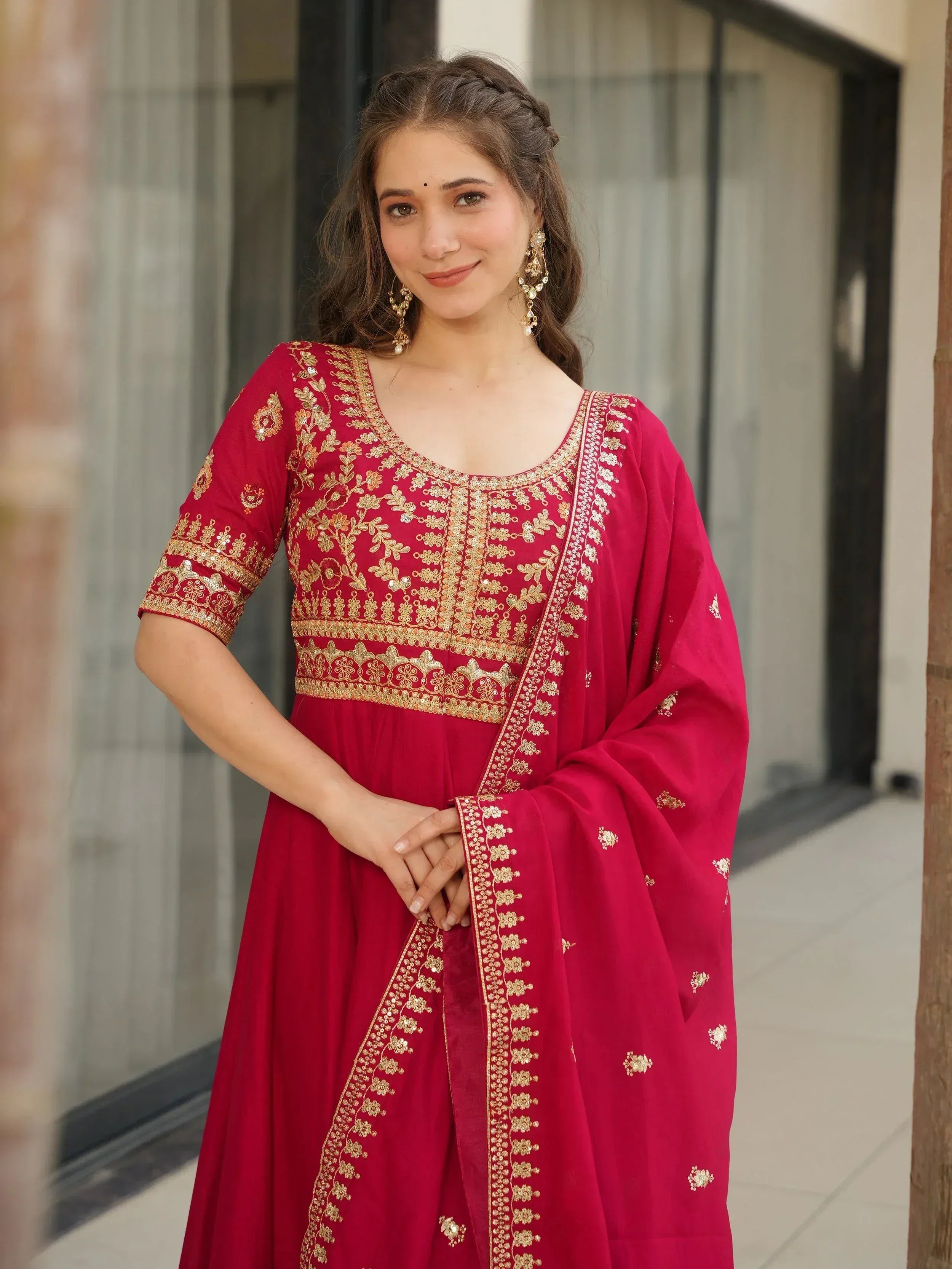 Red embroidered ethnic gown with gold detailing, perfect for Indian celebrations and festive occasions.