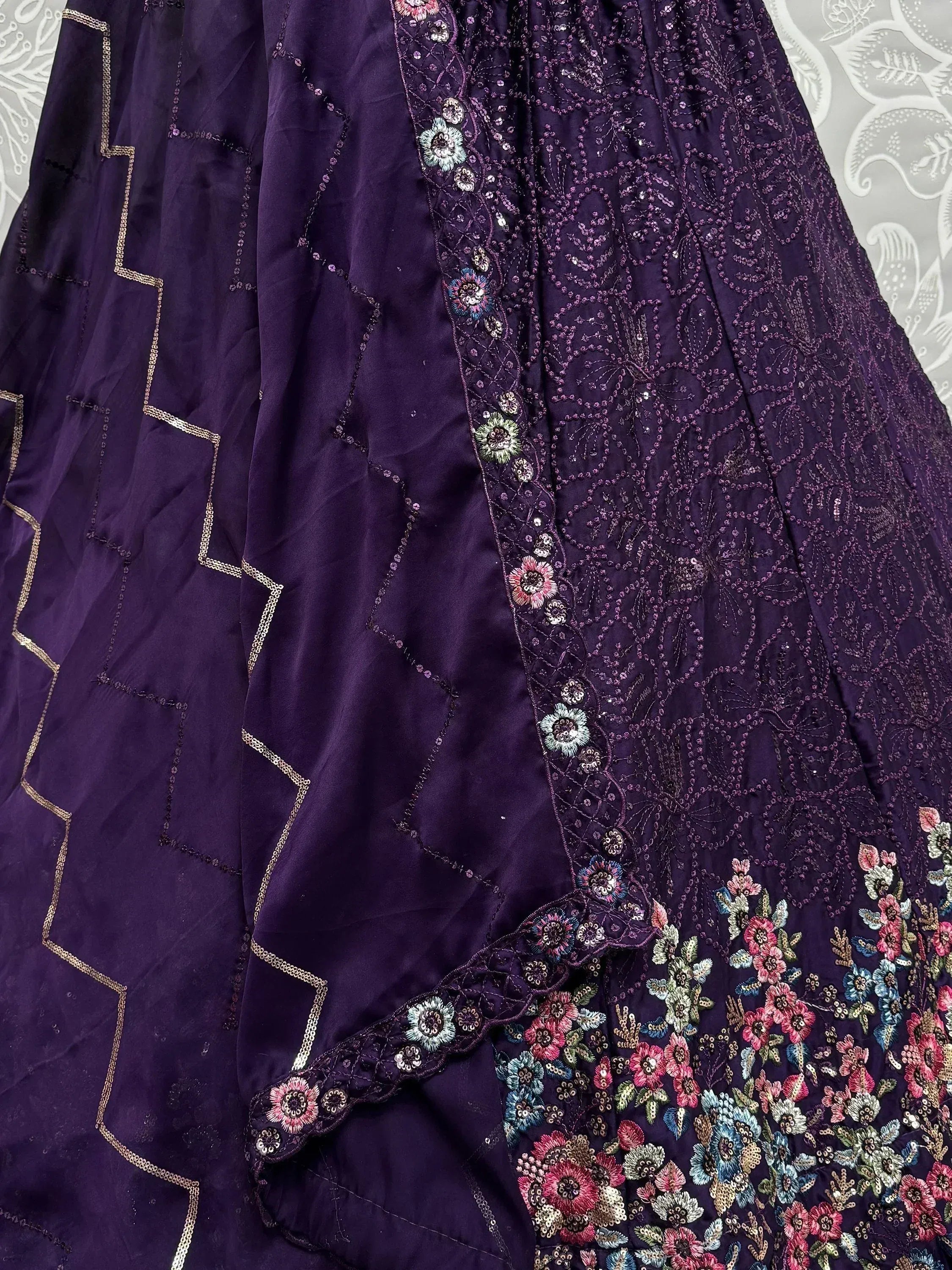 Purple ethnic lehenga with floral embroidery and gold detailing, perfect for Indian weddings or festivals.
