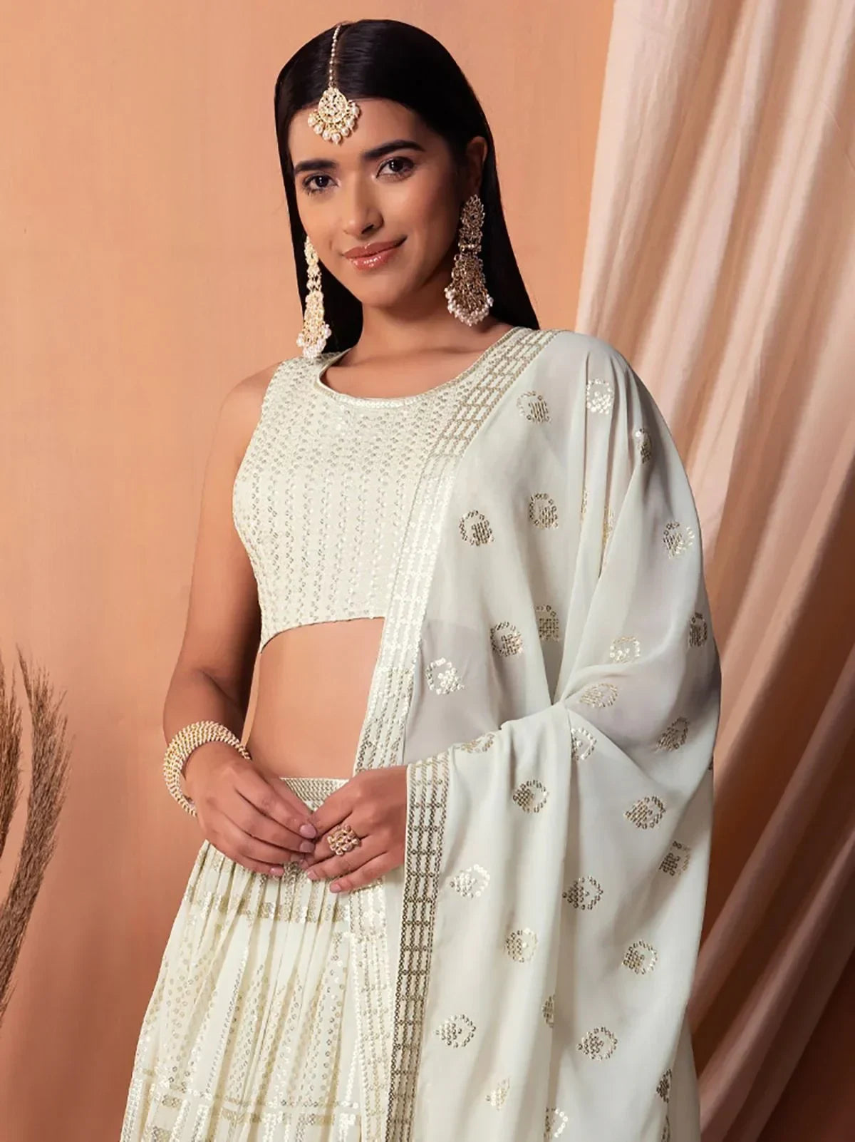Elegant white embroidered lehenga choli with gold detailing, perfect for Indian ethnic wear occasions.