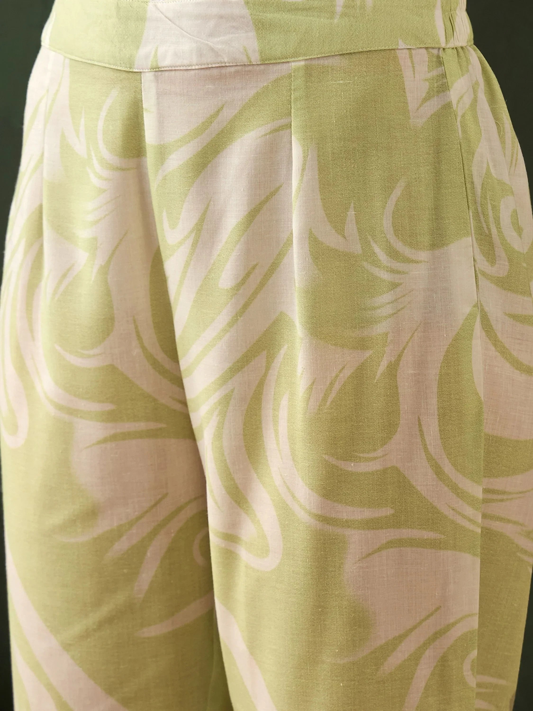 Close-up of light green and beige abstract print ethnic pants with pleated details