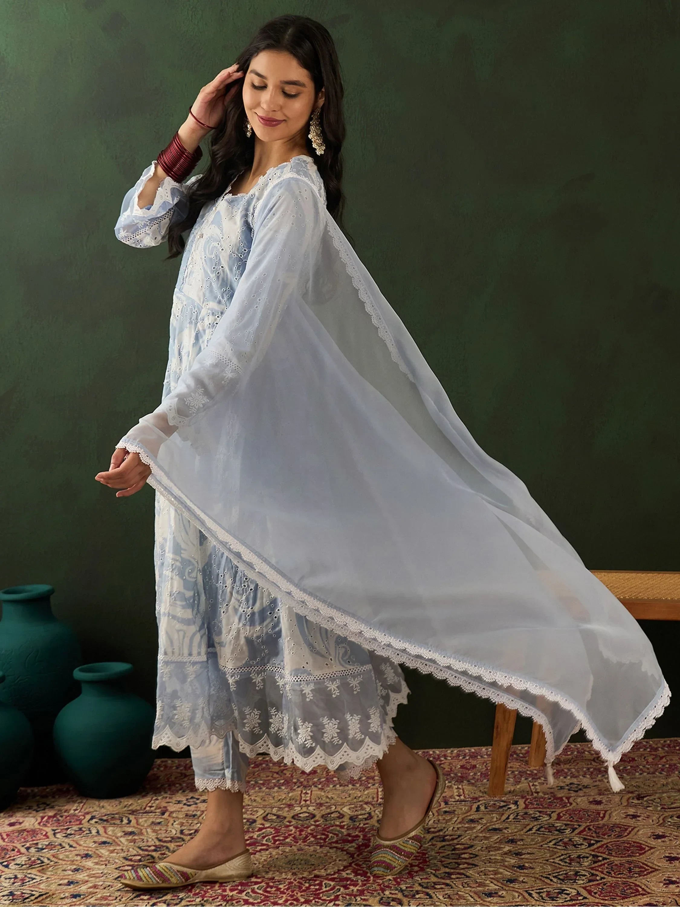Woman in light blue embroidered salwar kameez with dupatta, traditional Indian attire