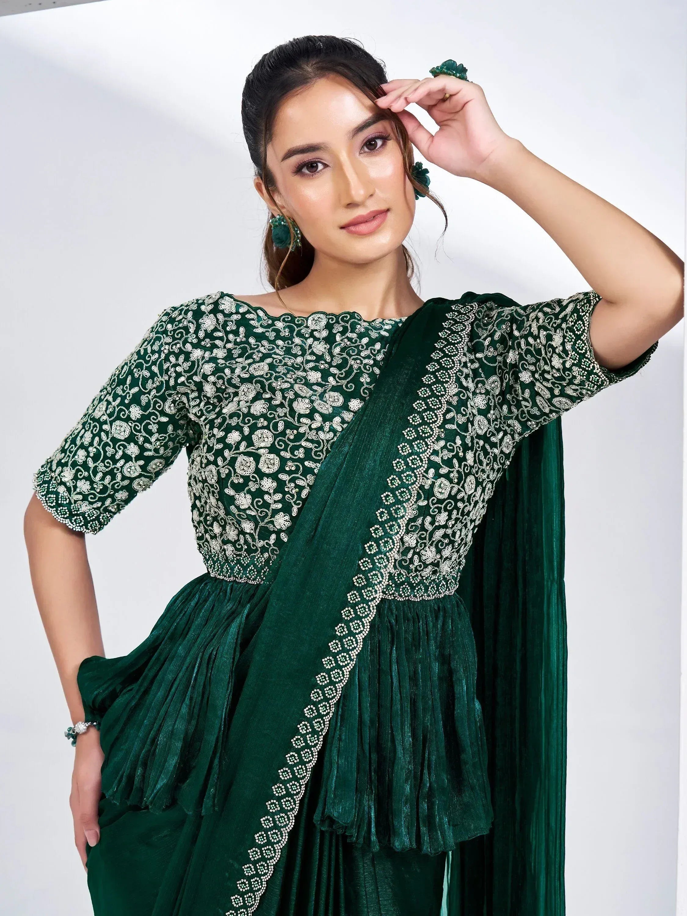 Emerald green embroidered ethnic gown with floral detailing and pleated skirt, perfect for Indian occasions.