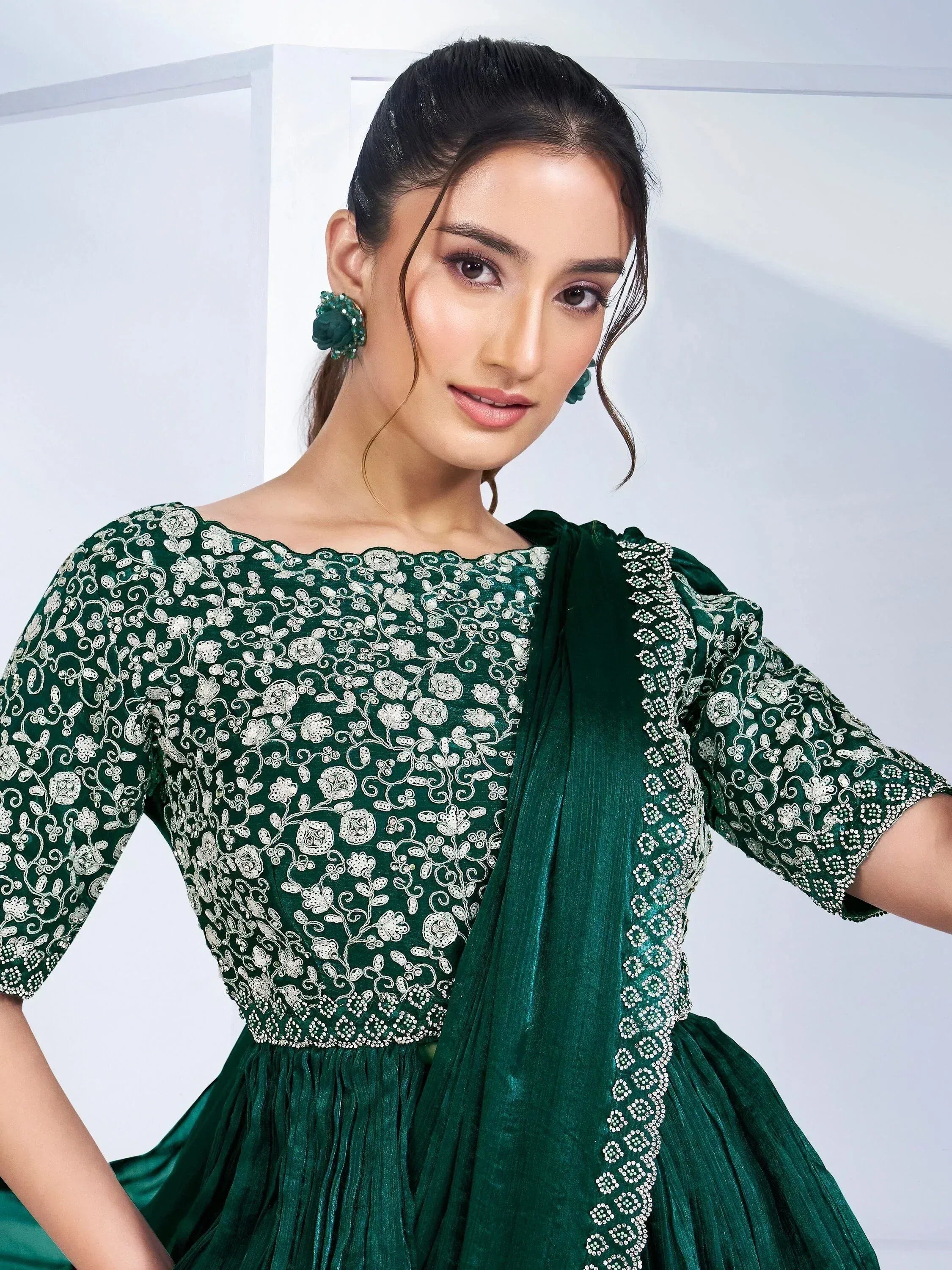 Emerald green embroidered ethnic gown with floral lace and matching dupatta, perfect for Indian occasions.
