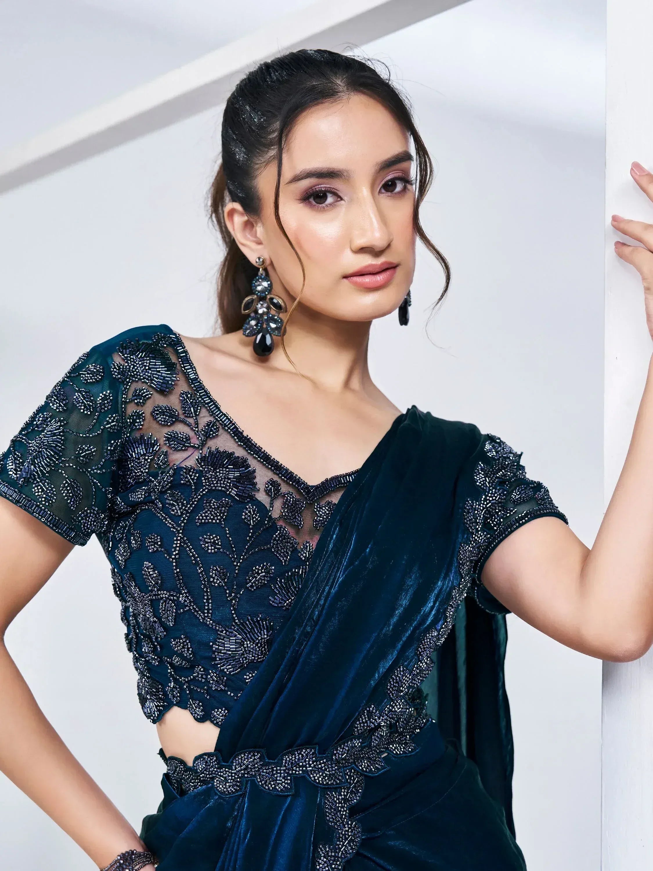 Elegant teal velvet saree with intricate beadwork and sheer blouse, perfect for Indian ethnic occasions.