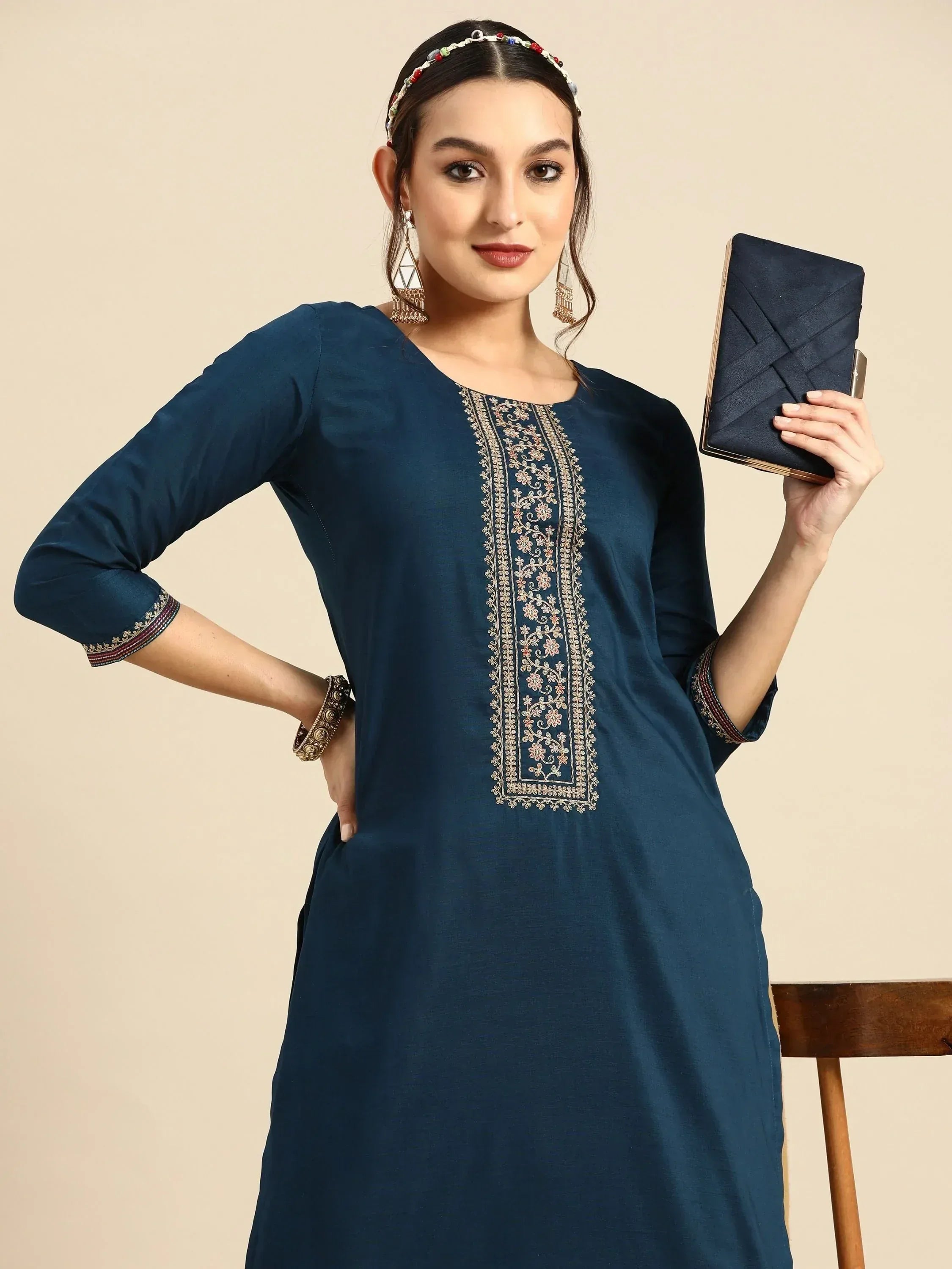 Woman in navy blue embroidered ethnic kurta with matching clutch and traditional jewelry