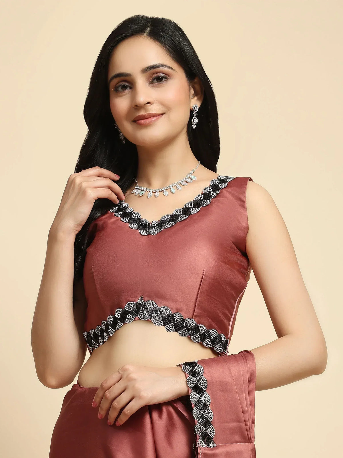 Dusty rose satin lehenga choli with black and silver embellished neckline and hem, paired with statement jewelry