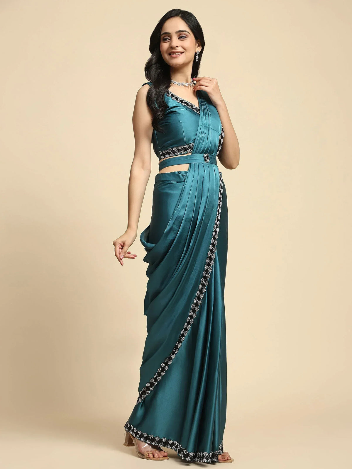 Teal satin saree with black and white embroidered border, styled with matching blouse and jewelry for ethnic wear