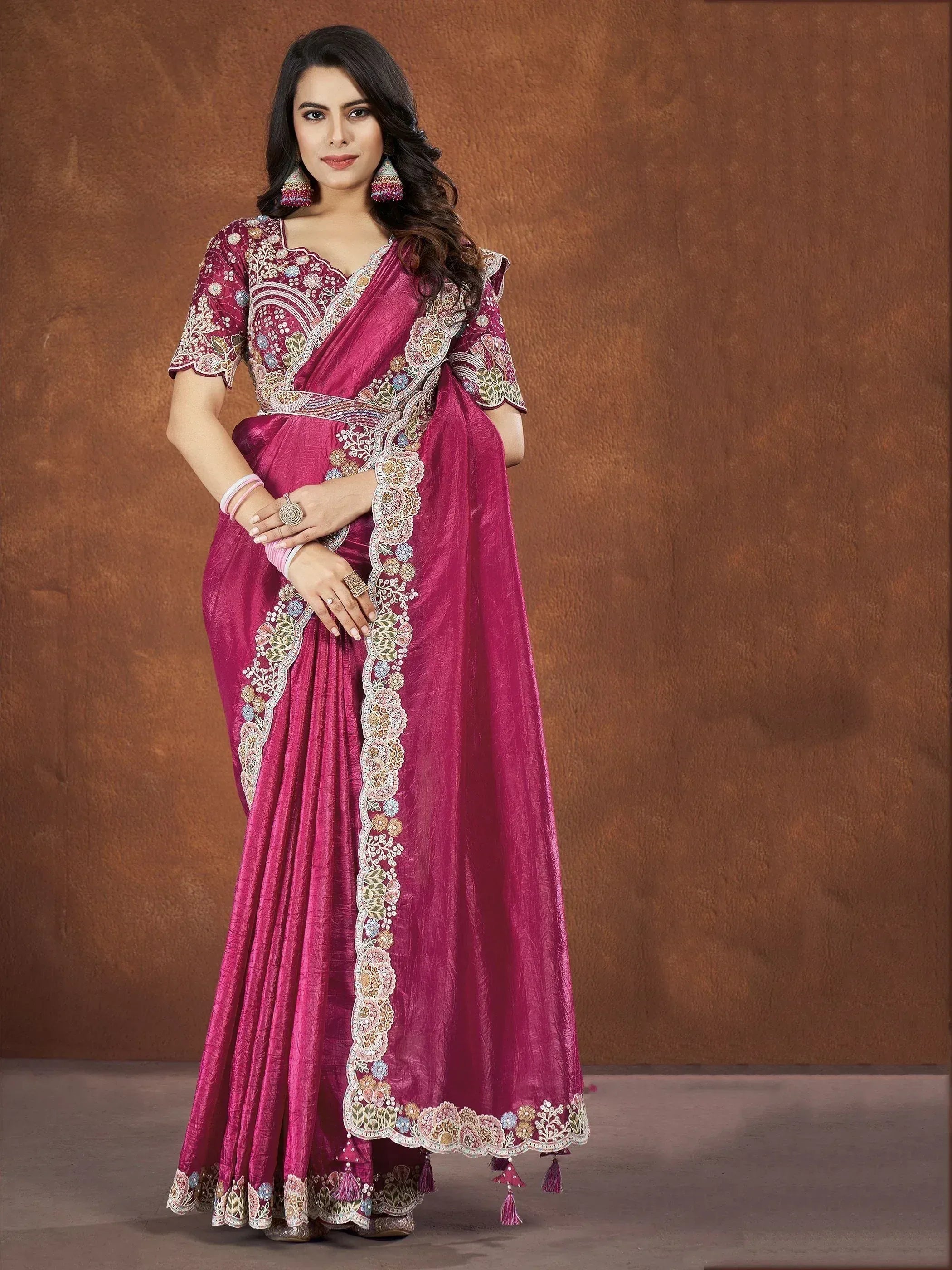 Elegant magenta saree with intricate floral embroidery and tassels, perfect for Indian ethnic occasions