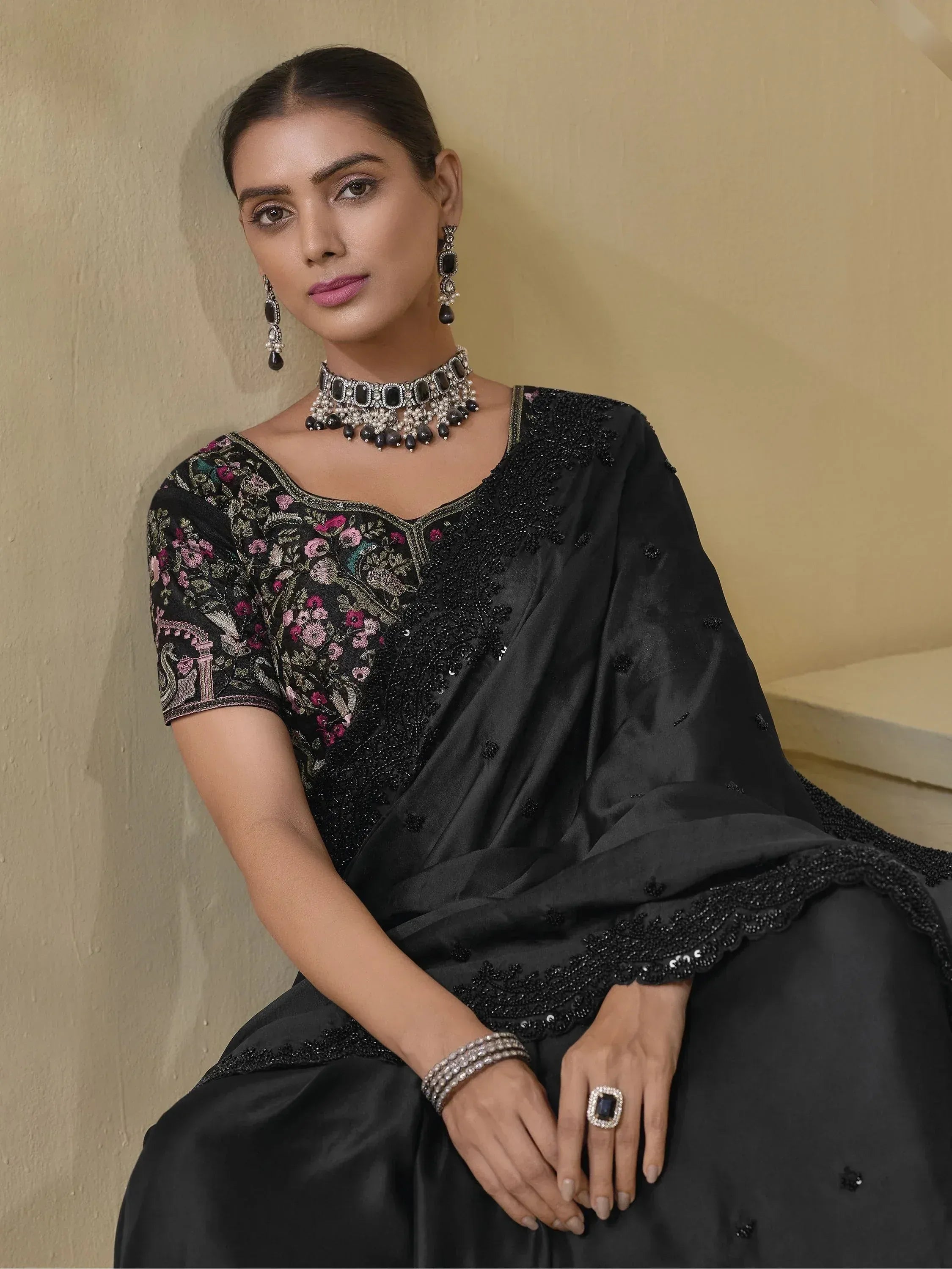 Black embroidered saree with floral motifs, paired with statement jewelry for ethnic wear