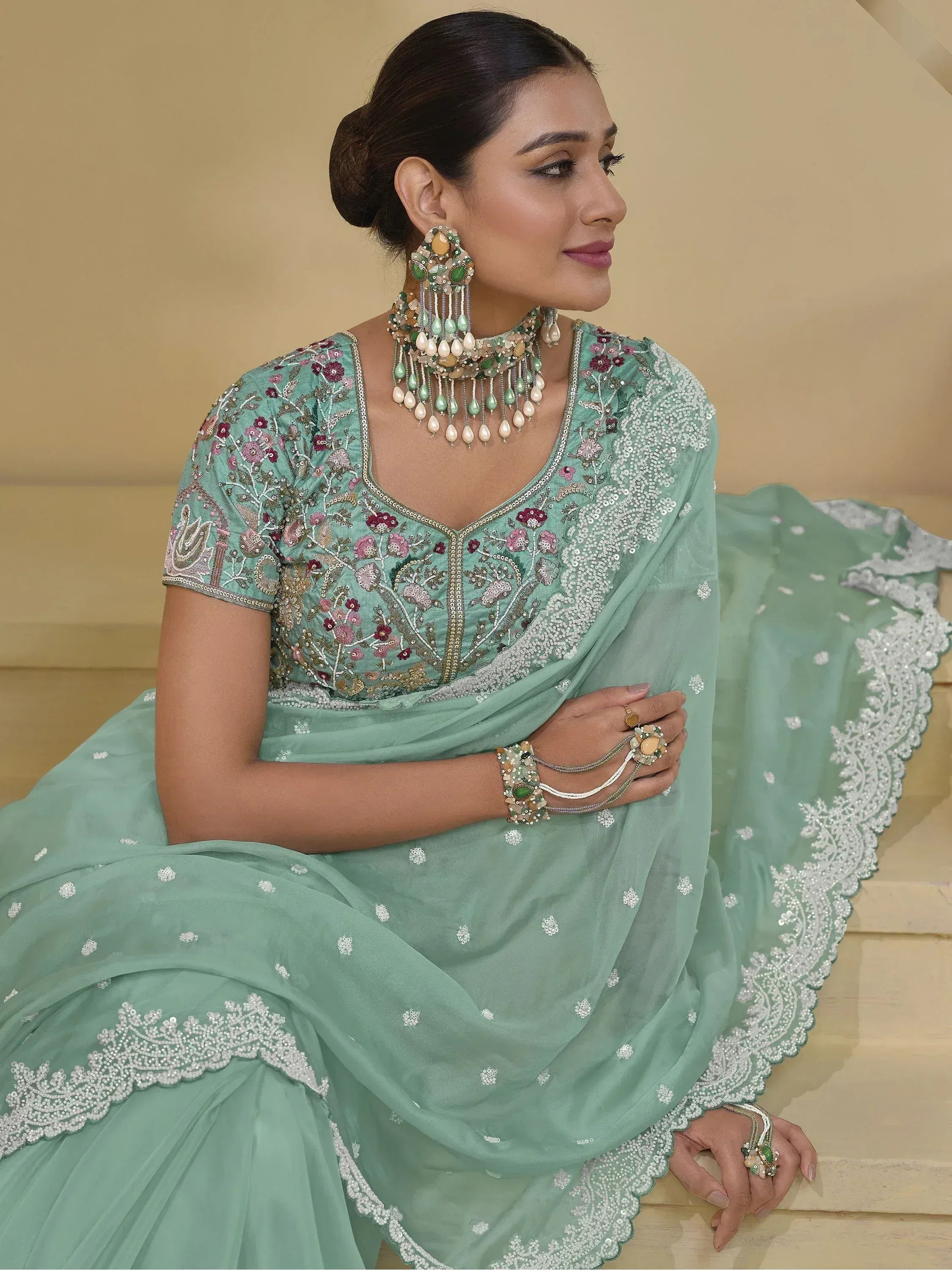 Mint green embroidered lehenga choli with floral detailing and matching jewelry for Indian ethnic wear