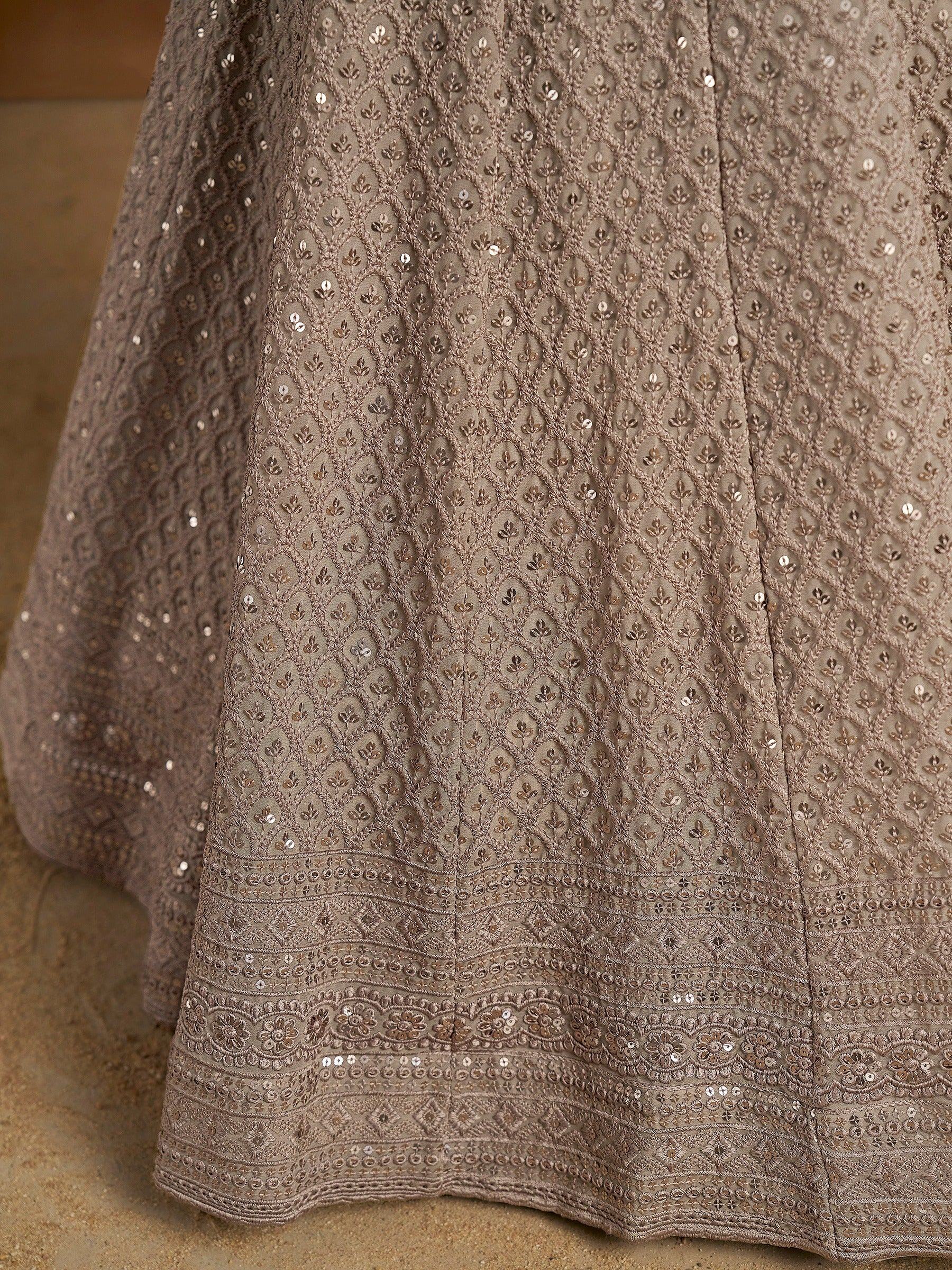 Elegant brown ethnic gown with intricate embroidery and sequin detailing, perfect for Indian festive occasions.