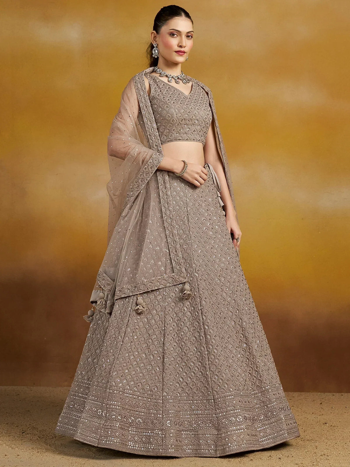 Elegant beige lehenga choli with intricate embroidery and sequin work, perfect for Indian weddings and festive occasions.