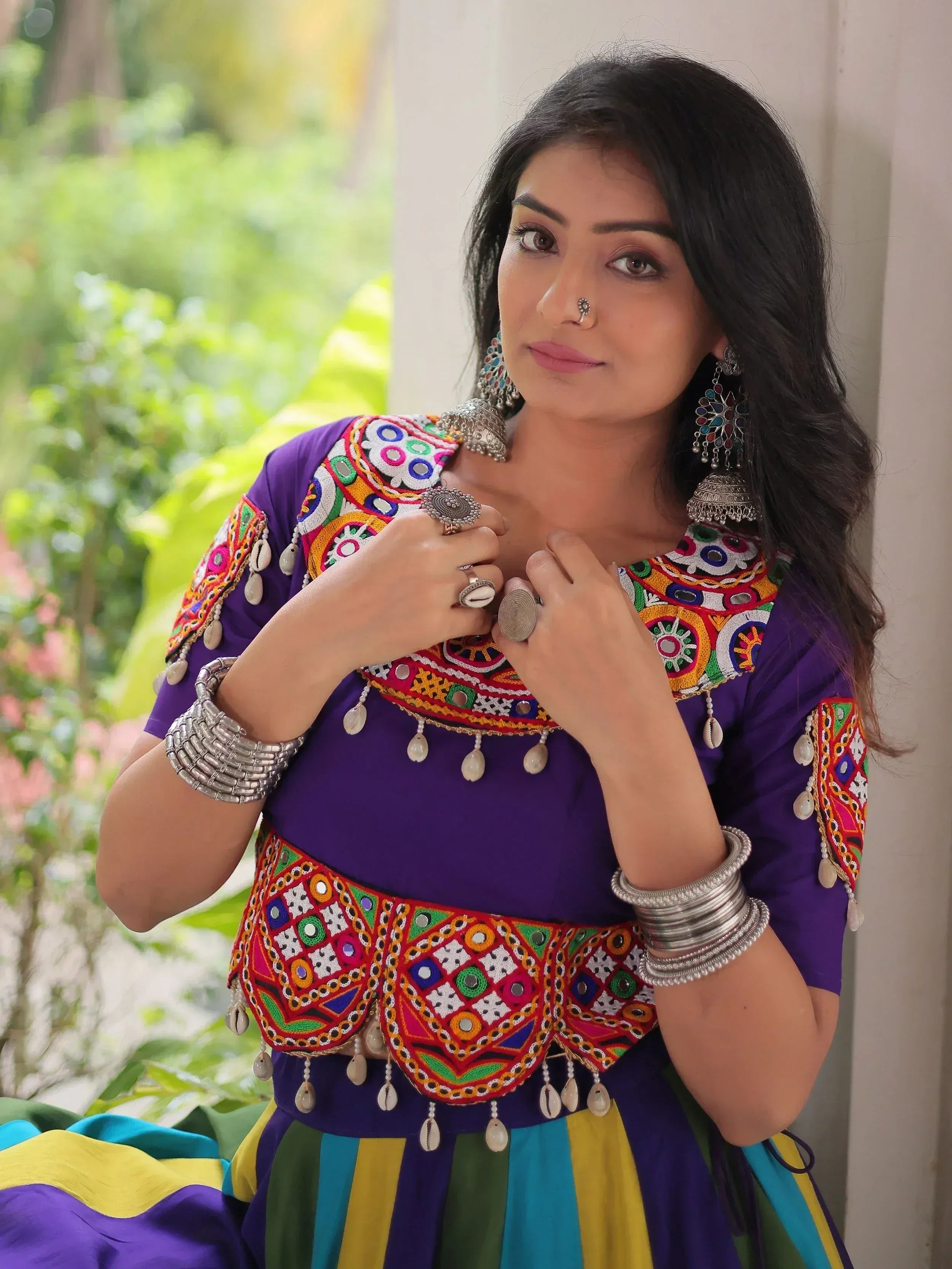 Vibrant purple ethnic wear with colorful embroidery and traditional jewelry